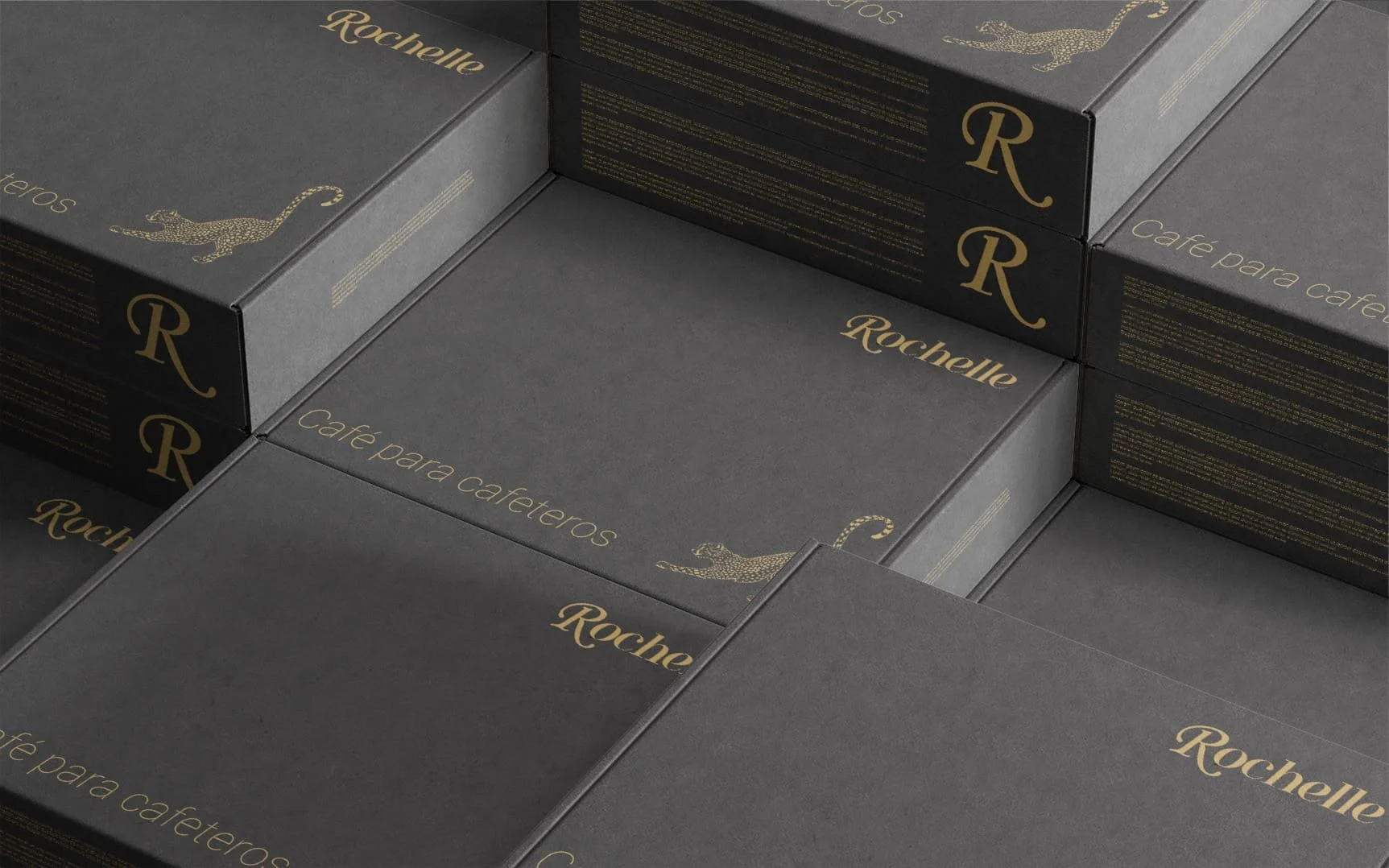 Cajas negras con letras doradas que dicen 'Rochelle' y 'Café para cafetoros', decoradas con una pantera dorada.