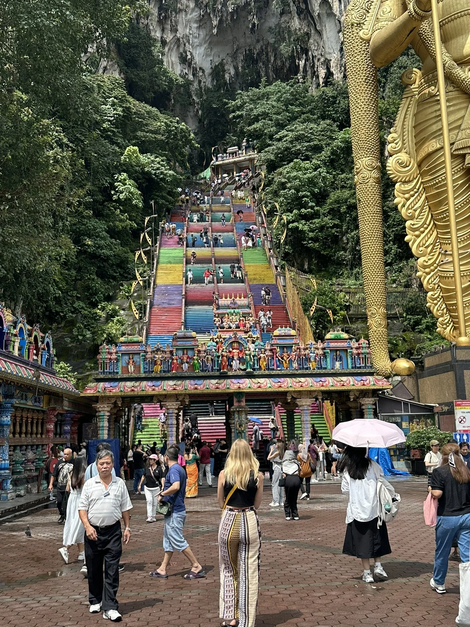 Batu Caves with coloured steps and golden buddha statue