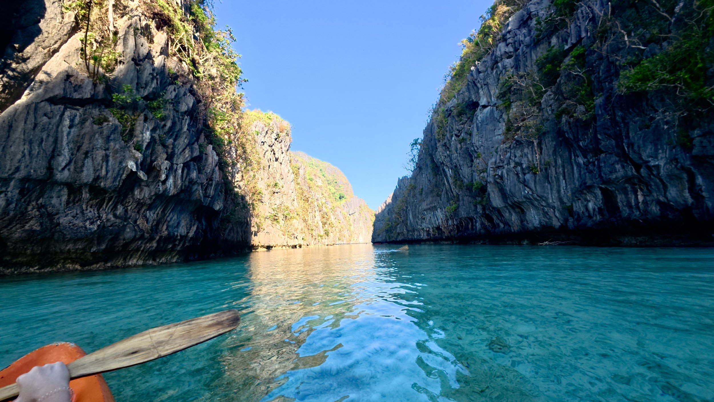 Kayak entering Big Lagoon between limestone cliffs, El Nido