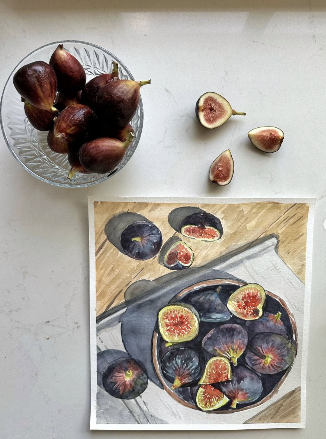 Photograph showing whole and halved figs on a glass dish and a watercolor art illustration of figs.