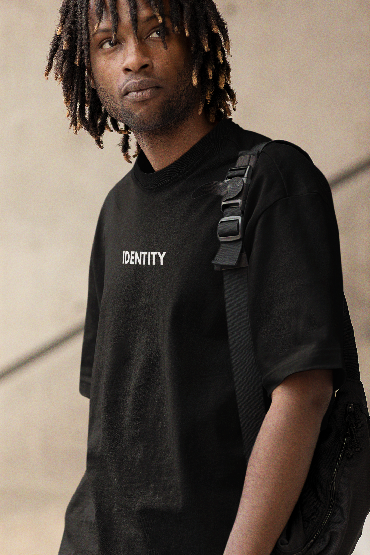 mockup-of-a-serious-man-with-locs-wearing-an-oversized-tee-and-carrying-a-bag-m25227.png