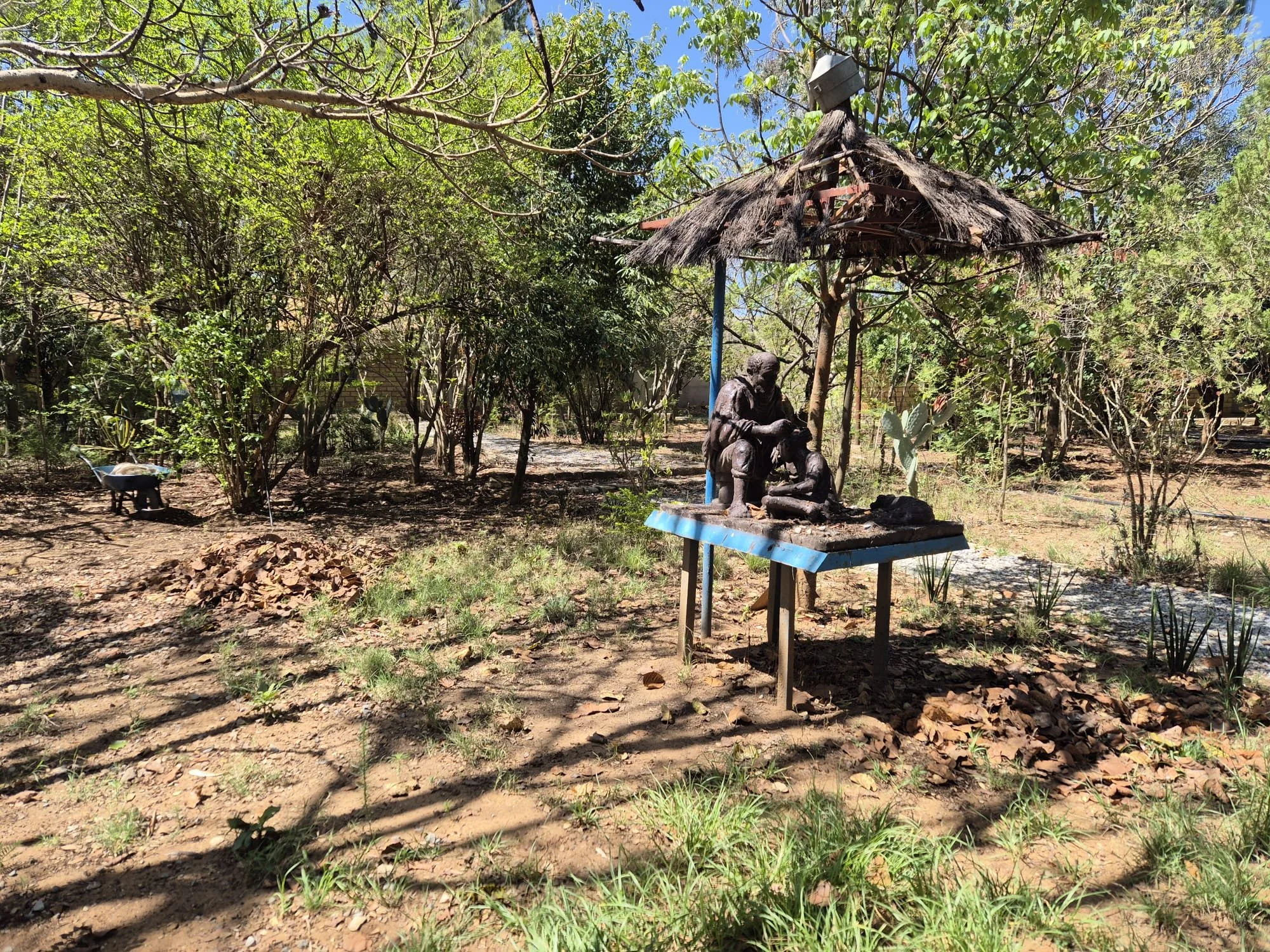 Sculpture depicting an elder teaching a child beneath a traditional shelter, symbolising the passing of knowledge and cultural heritage in Ethiopia.