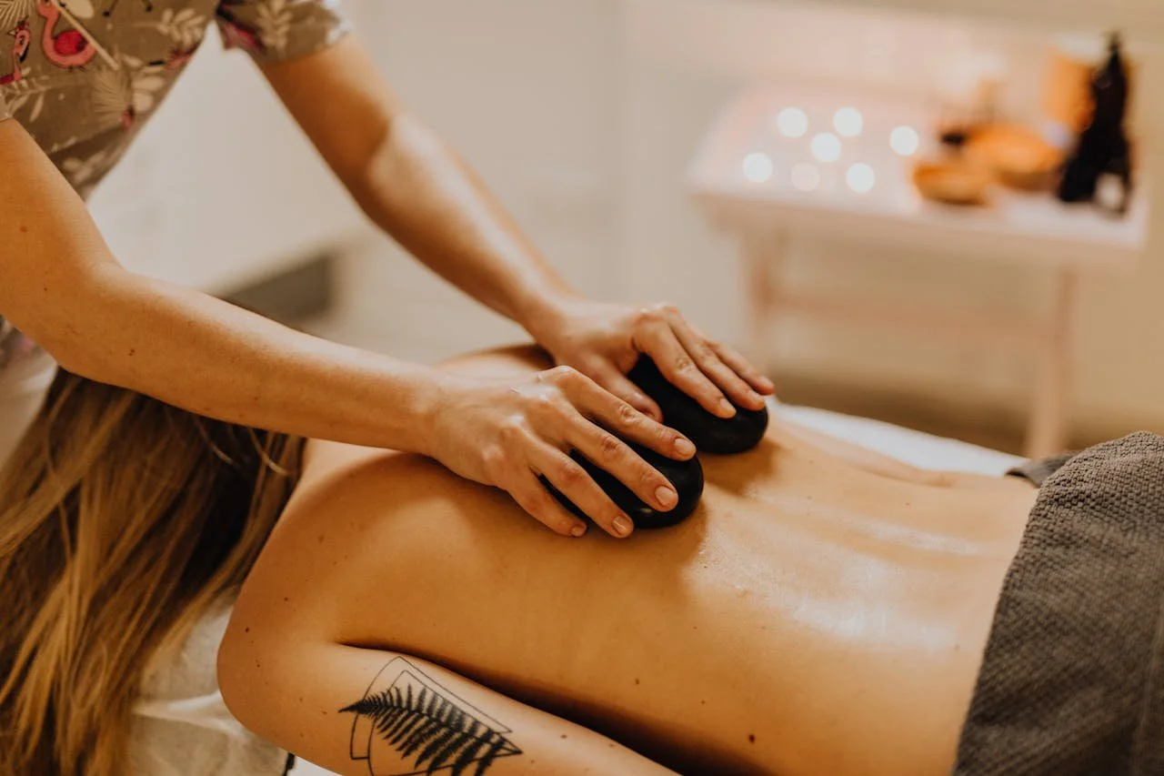 Heated stones placed along a client's back during a hot stone massage session at Silk Skin & Wellness in Woodbridge, VA