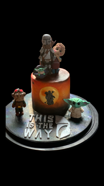 Cake decorated with characters from The Mandalorian, featuring Grogu, Mandalorian, and others, with a 'This is the Way' emblem on the base.