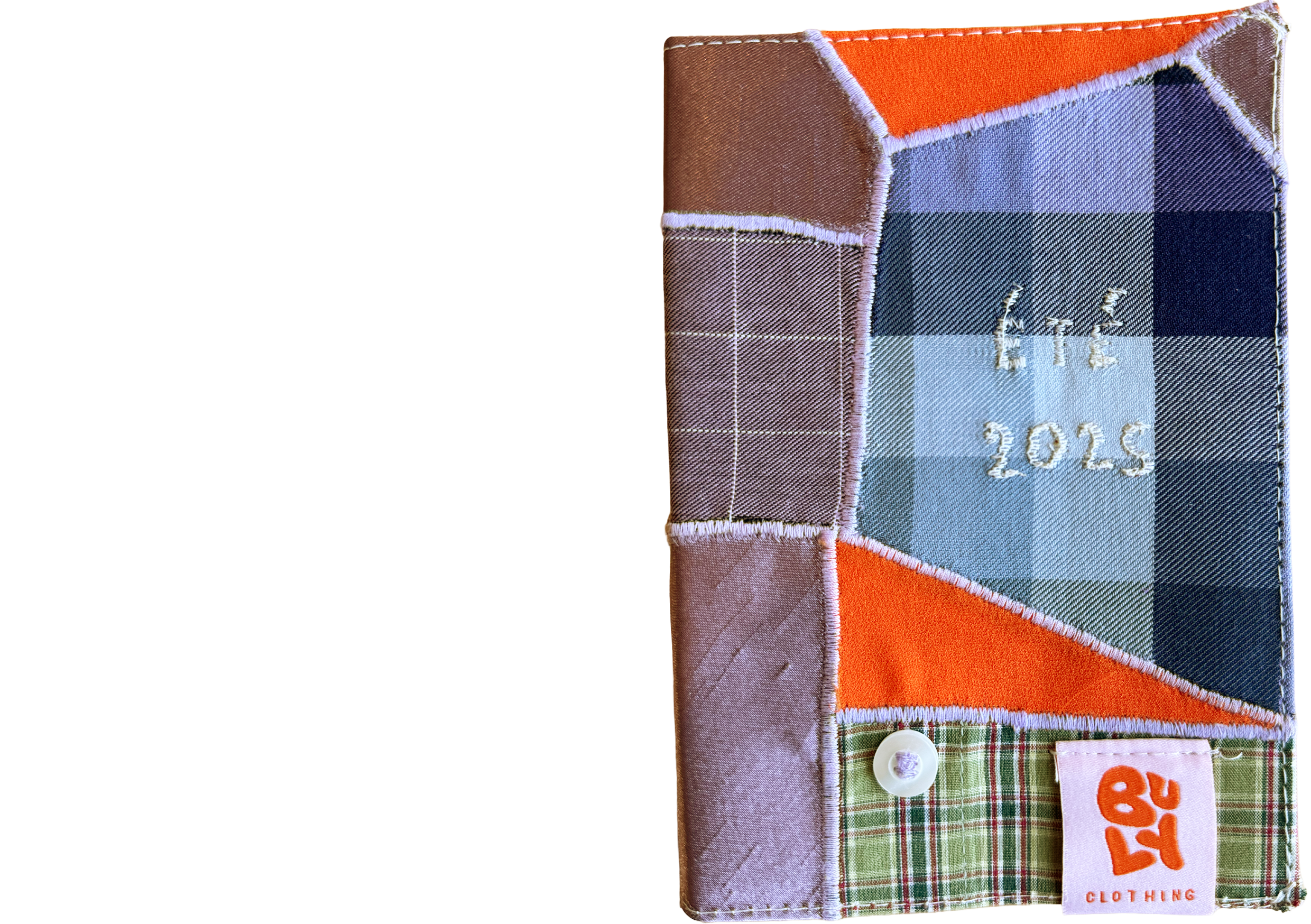 Une couverture de livre faite de morceaux de tissu colorés,  une étiquette orange et un petite bouton blanc.