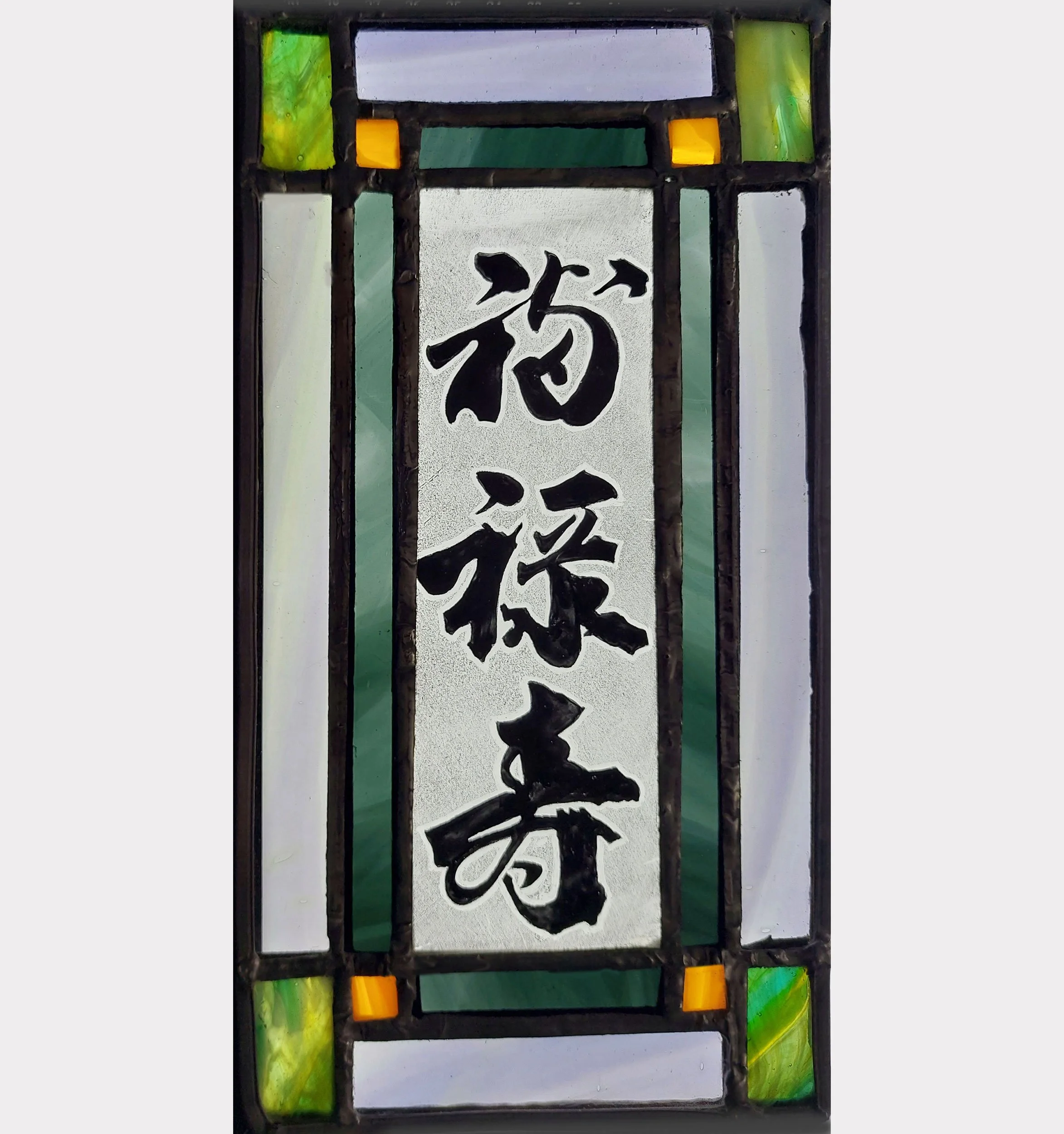 A stained glass panel with Japanese characters signifying a good and prosperous life.
