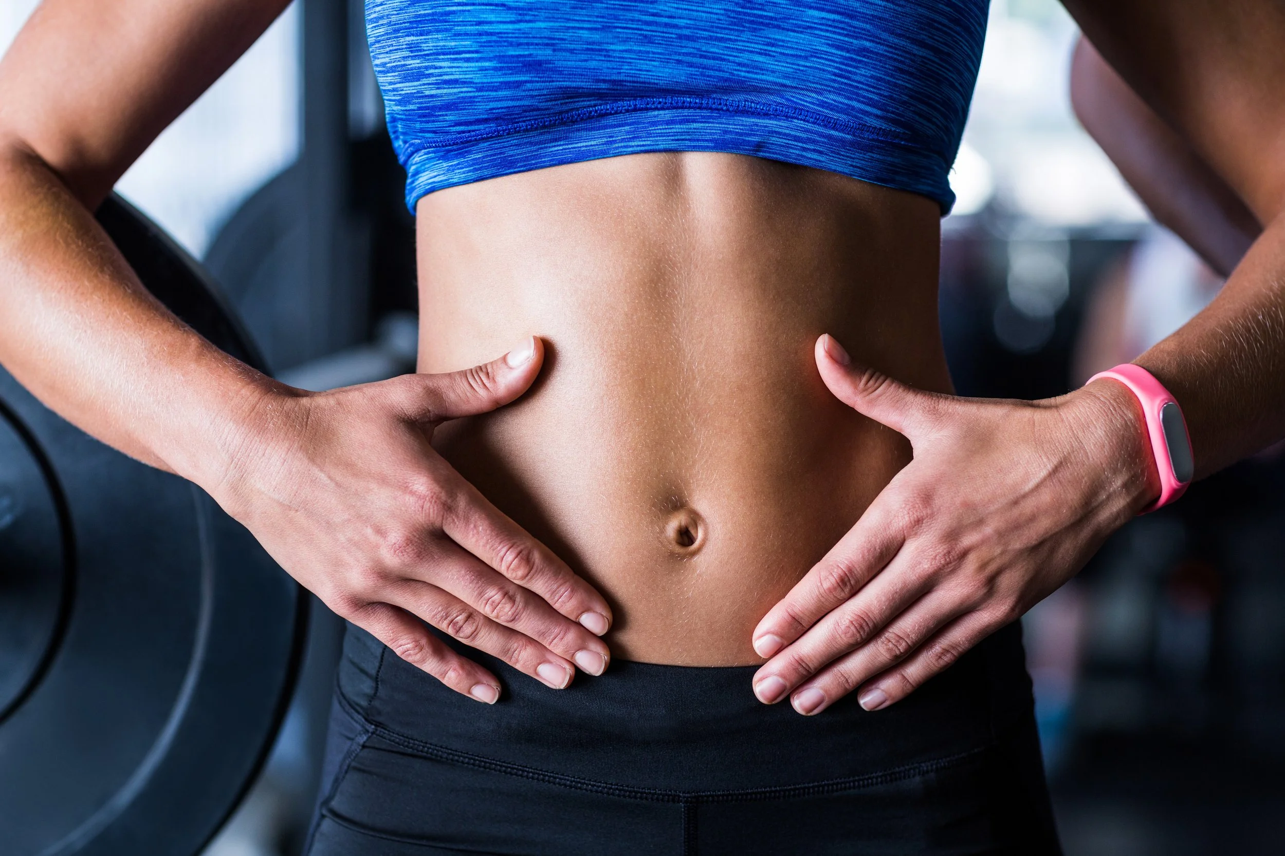 midsection of athlete touching belly - metabolic and weight optimization