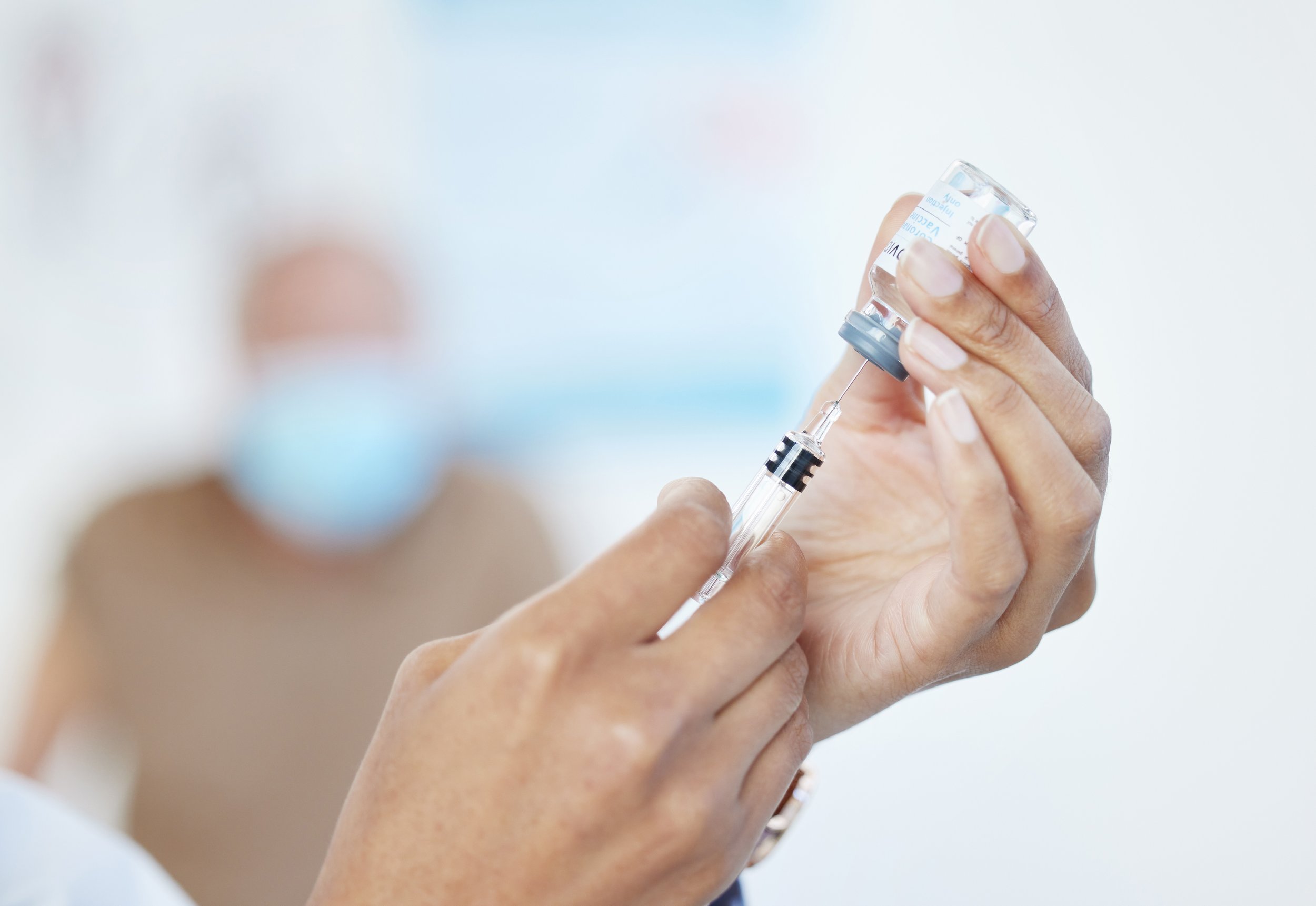 hands holding a vial and a syringe of injectable testosterone