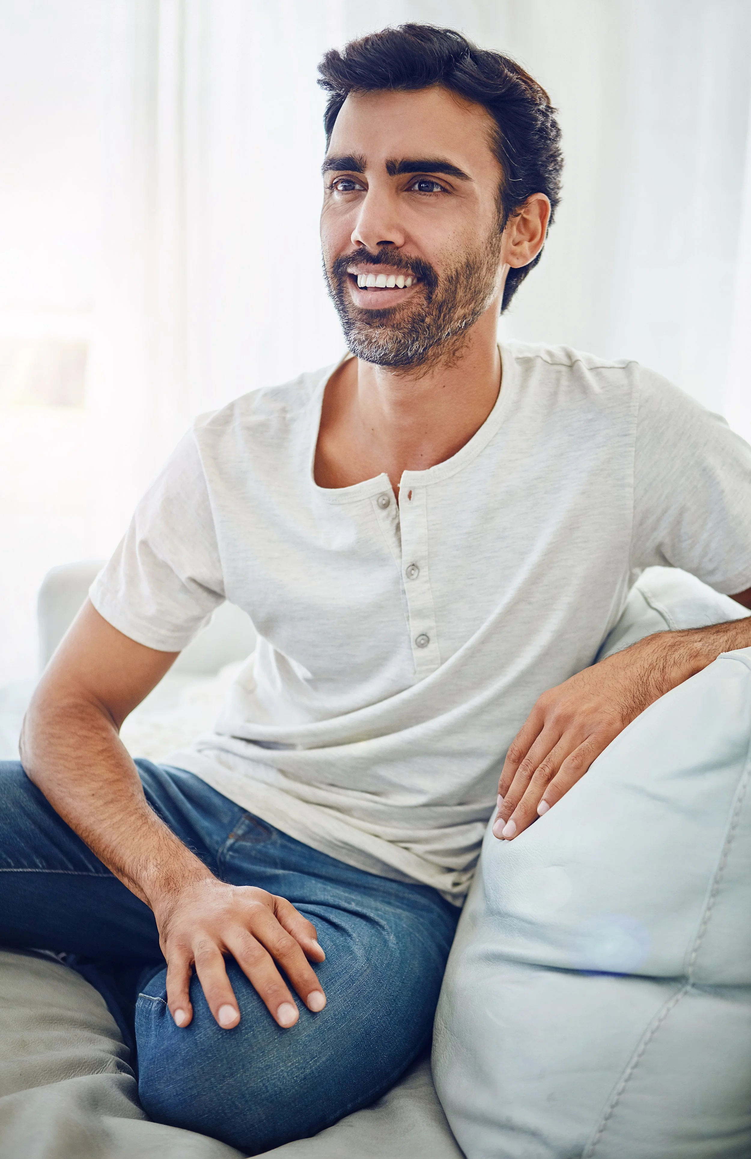 man relaxing in a sofa smiling white tshirt