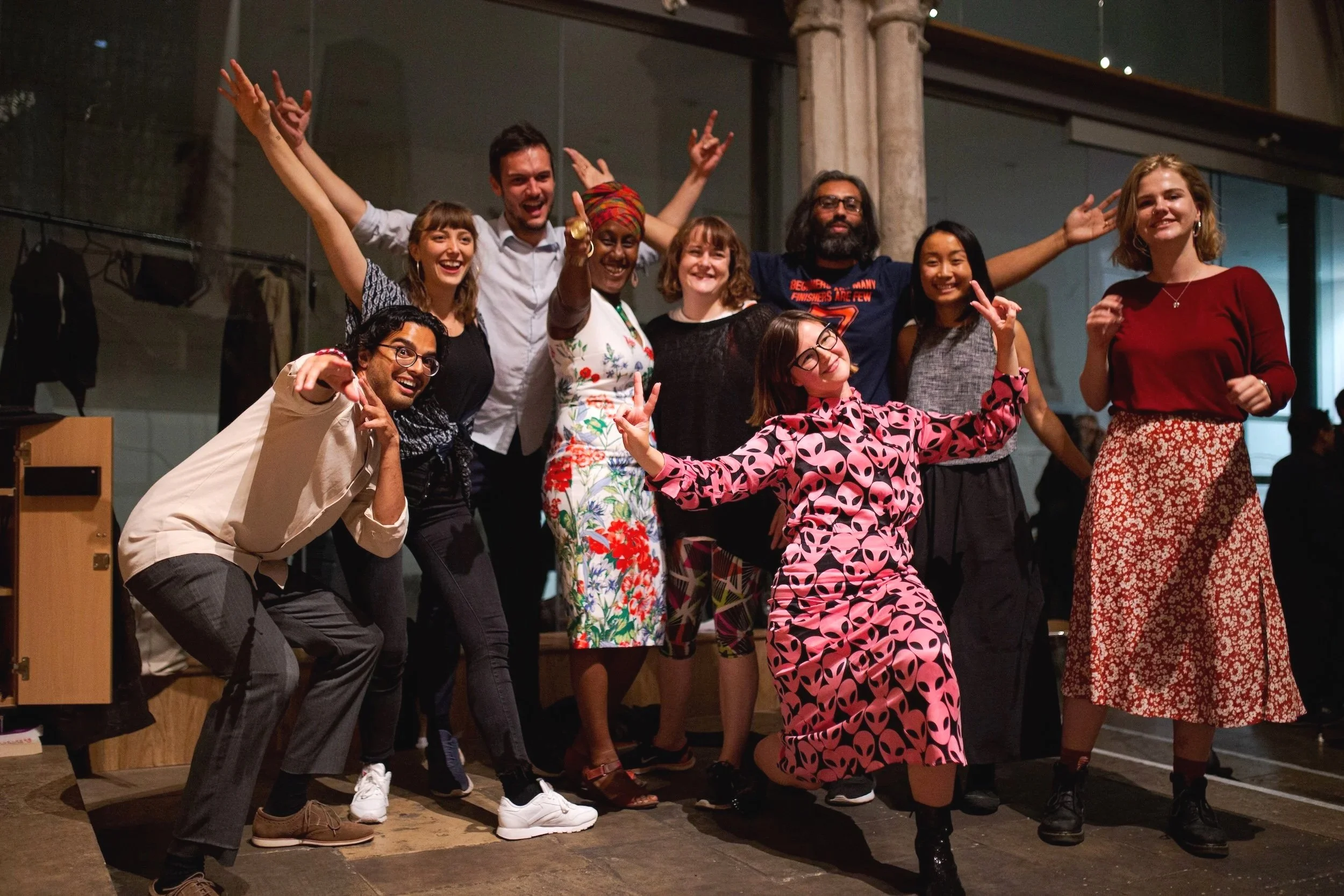 A smiling group of nine peer-to-peer learners, celebrating their Huddlecraft Showcase together.