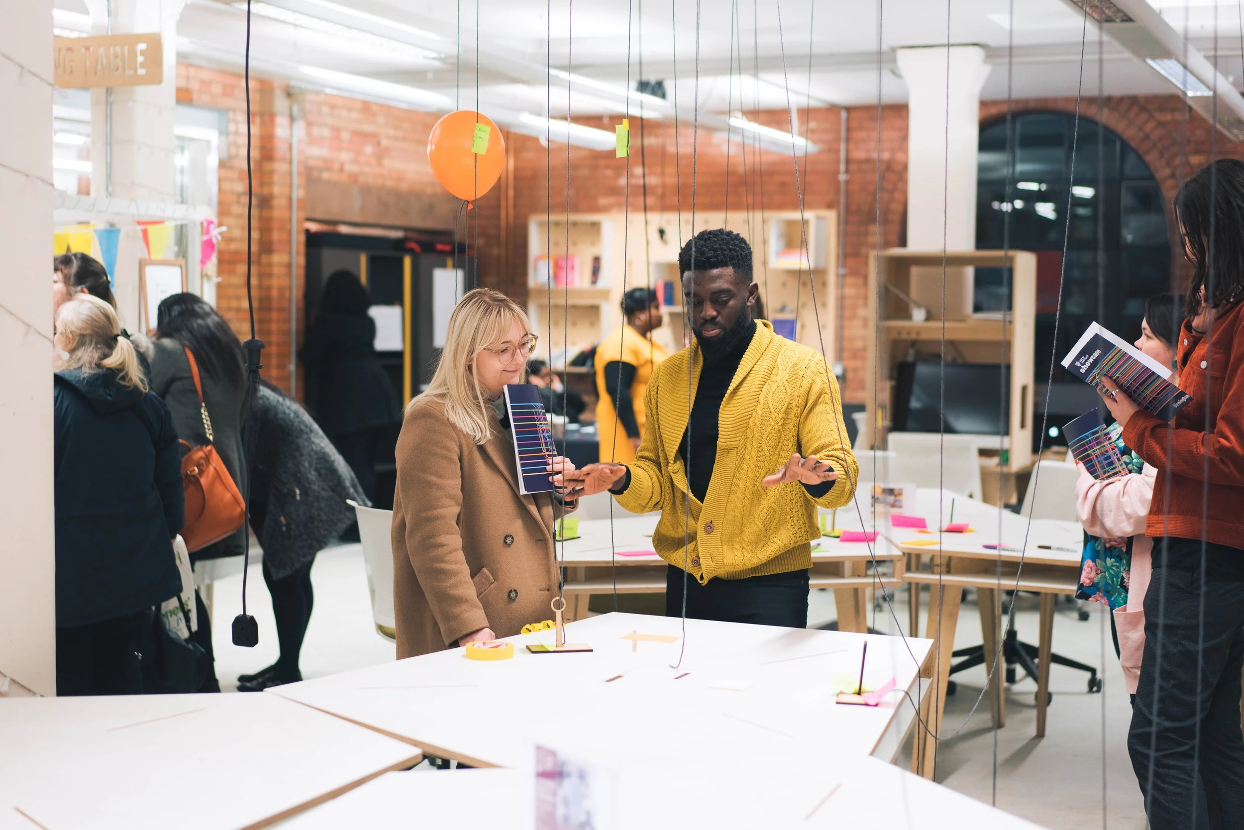 Huddle showcase - Two people talk in front of an exhibition display