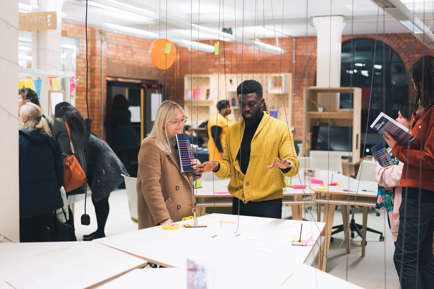 Huddle showcase - Two people talk in front of an exhibition display
