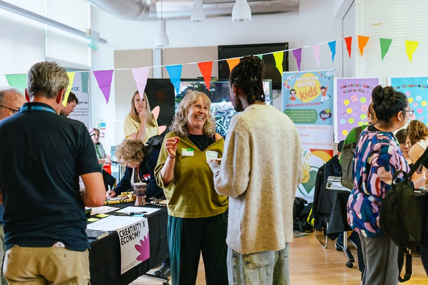 Economic Justice Huddles Showcase - Two attendees stand in the exhibition space and discuss