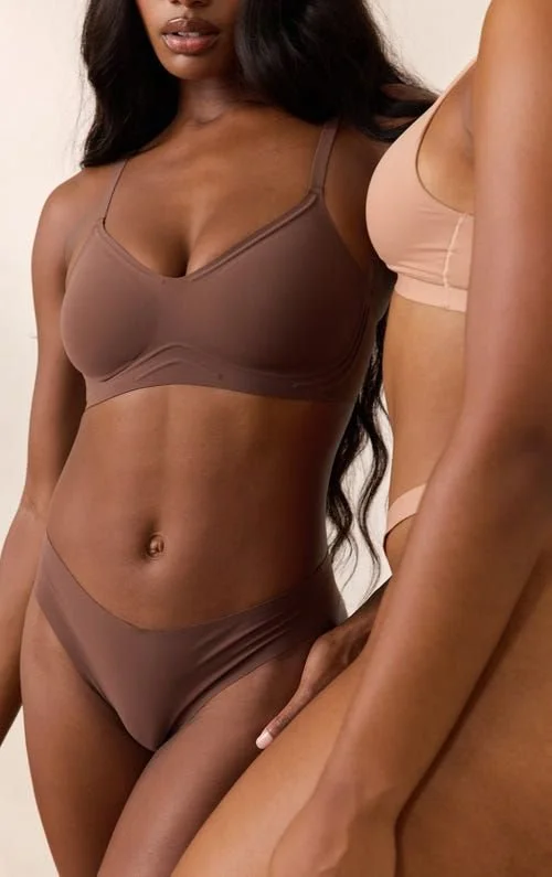 Deux femmes portant des sous-vêtements de couleur beige et marron, mettant en valeur leur silhouette.