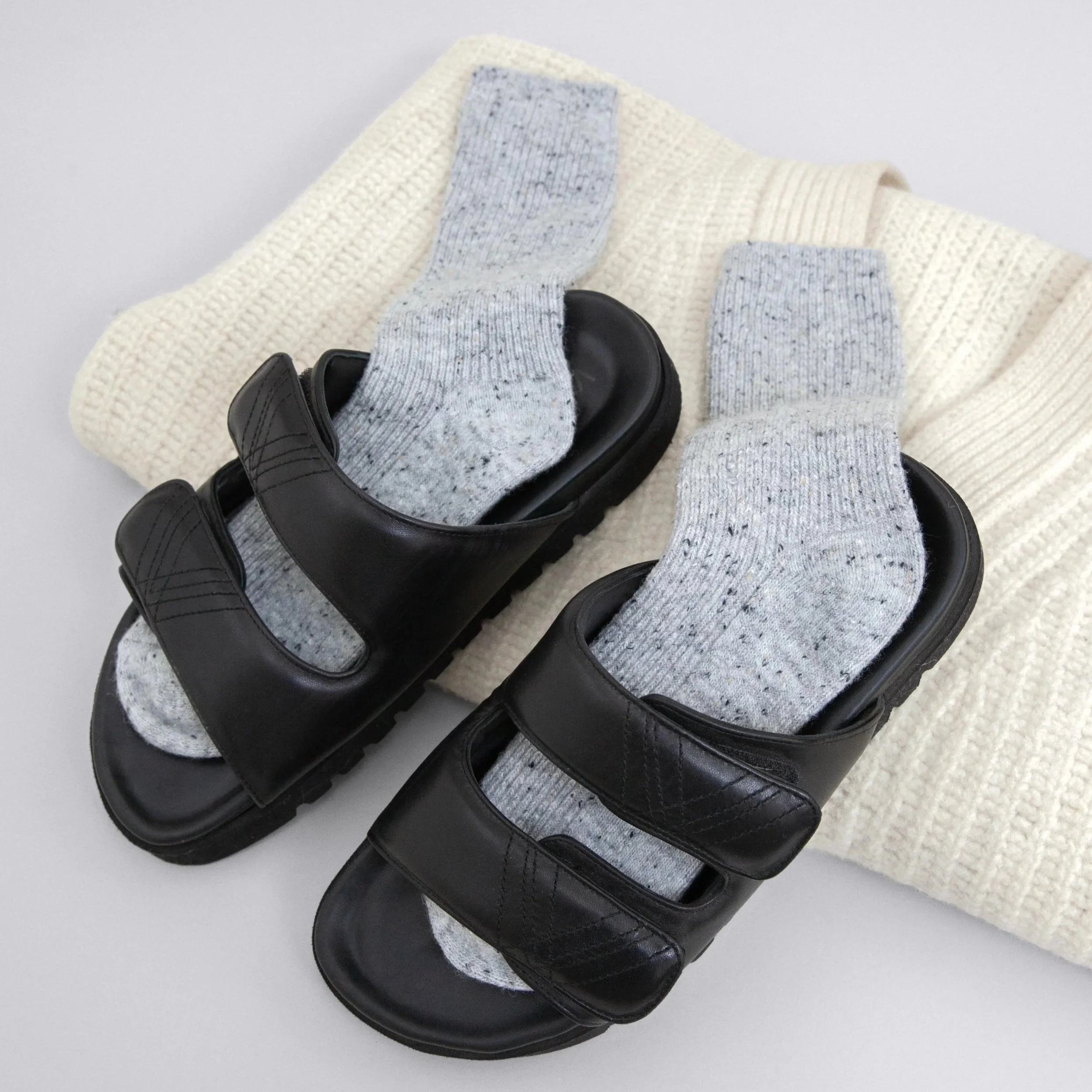 Still life photography of leather sandals with socks from le bon shoppe