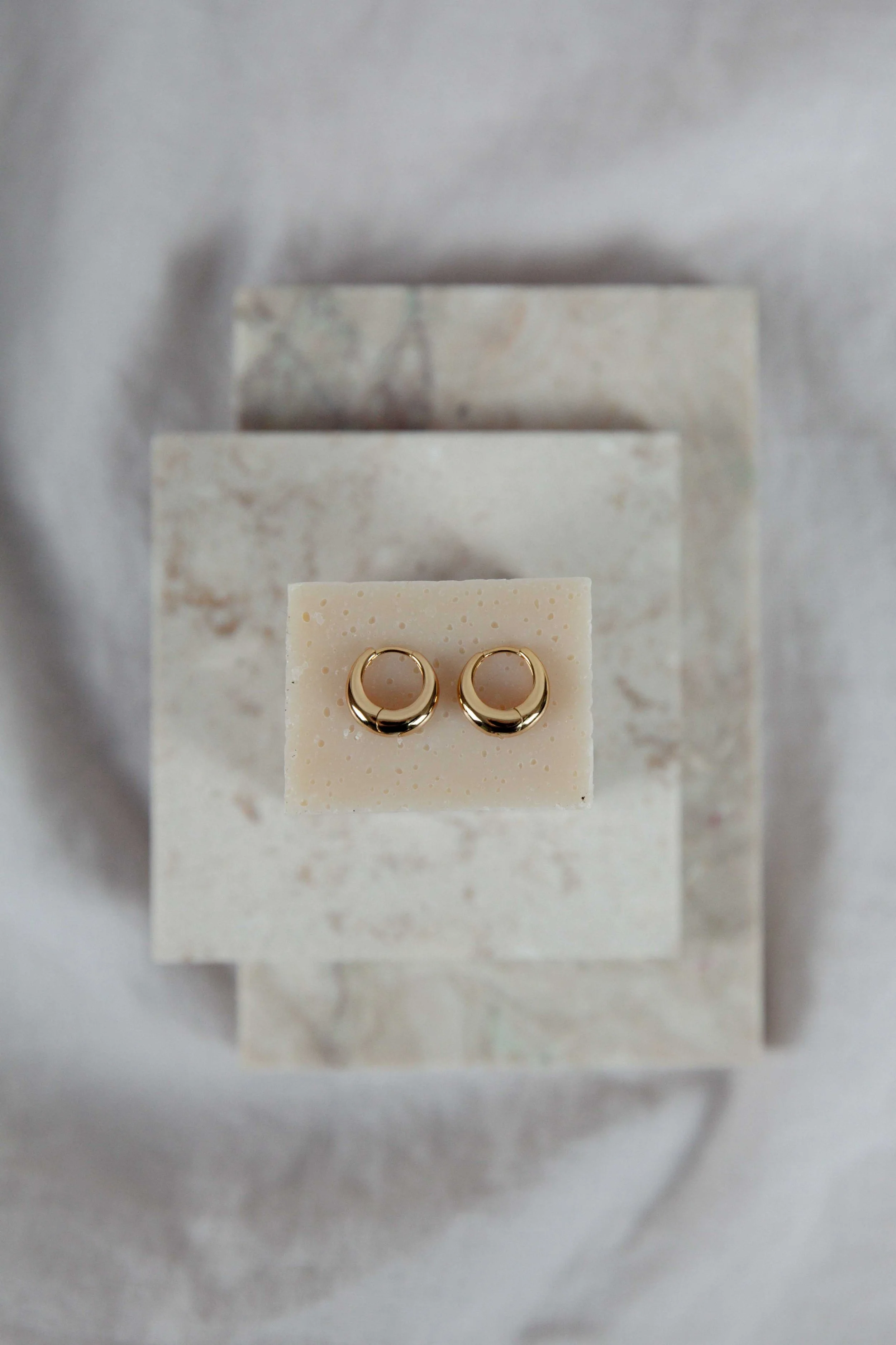 Still life photography of golden earrings from Brandlinger