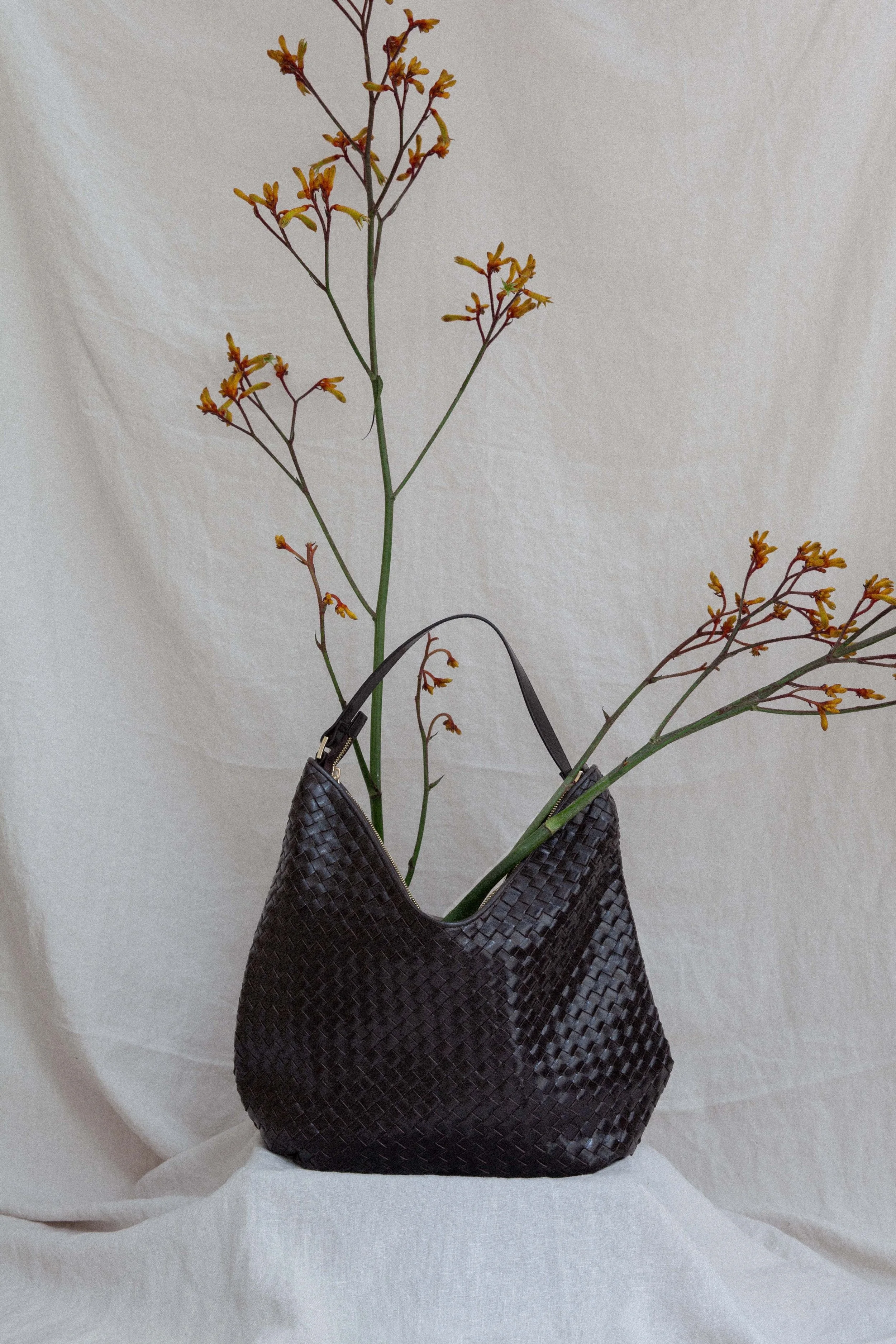 Still lige photography of a bag from Adax copenhagen shot with flower