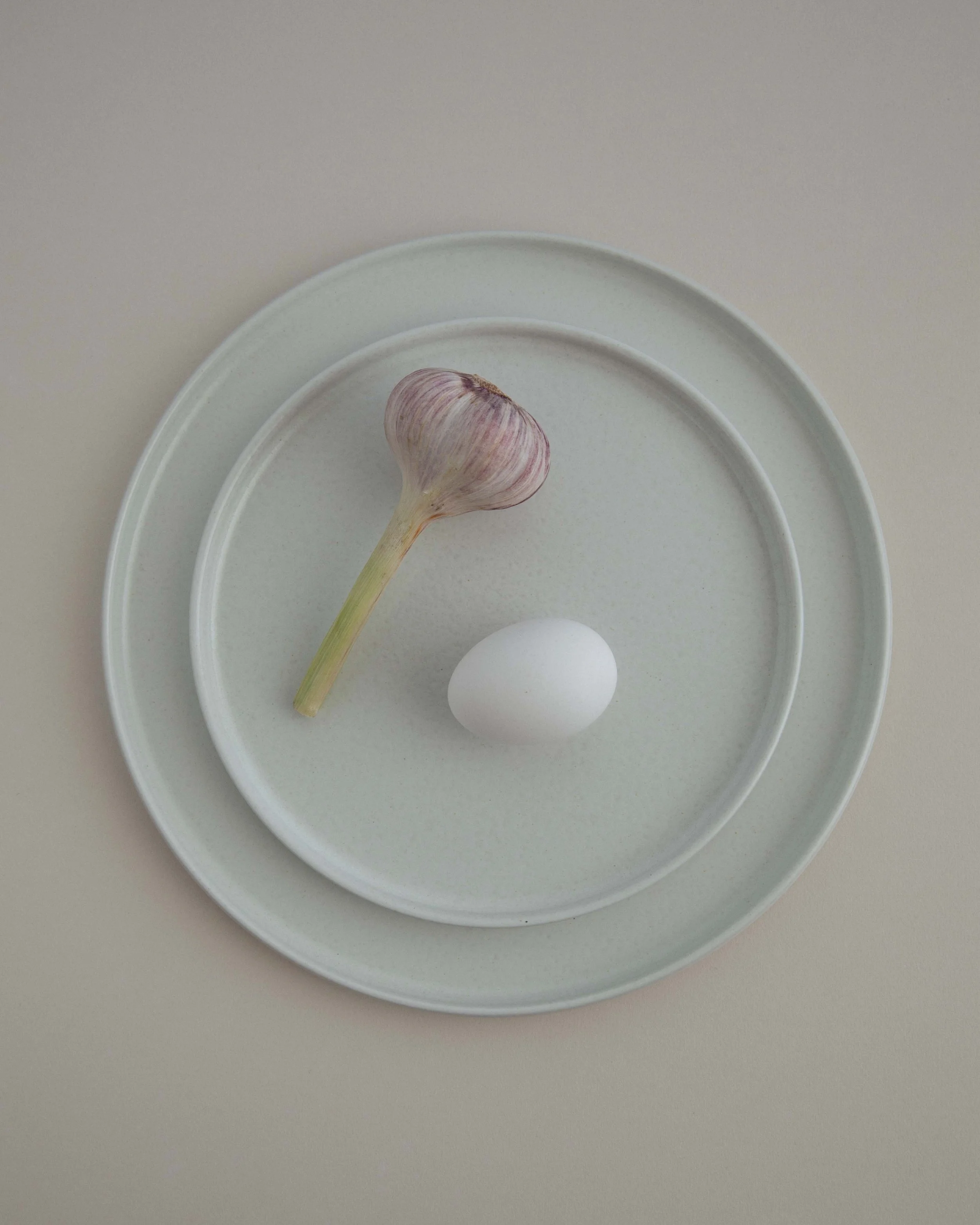 Still life photography of a garlic and egg on a ceramic plate from Costa Nova