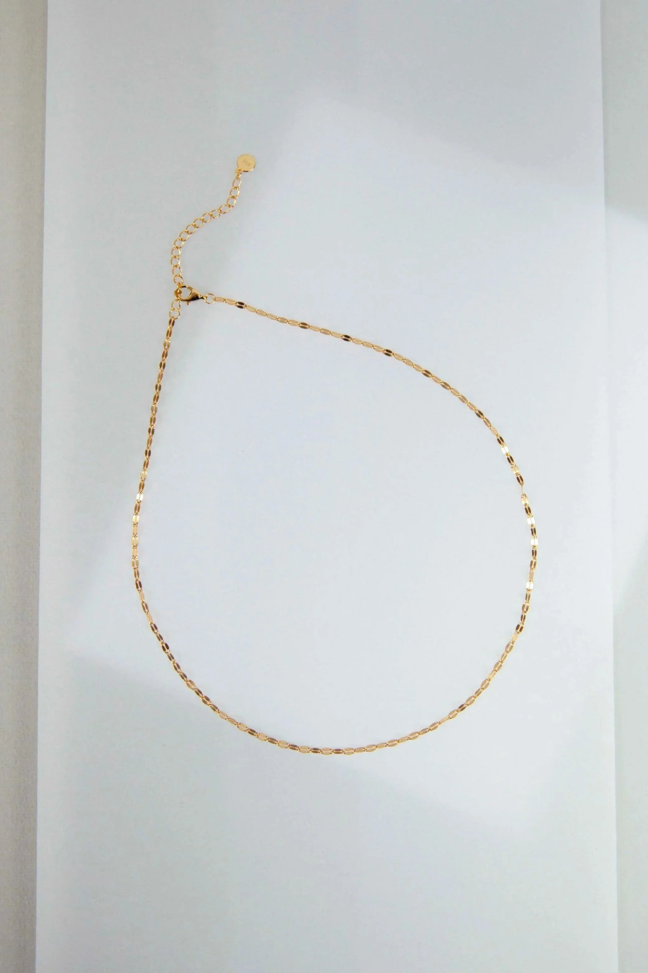 Still life photography with set design from golden necklace