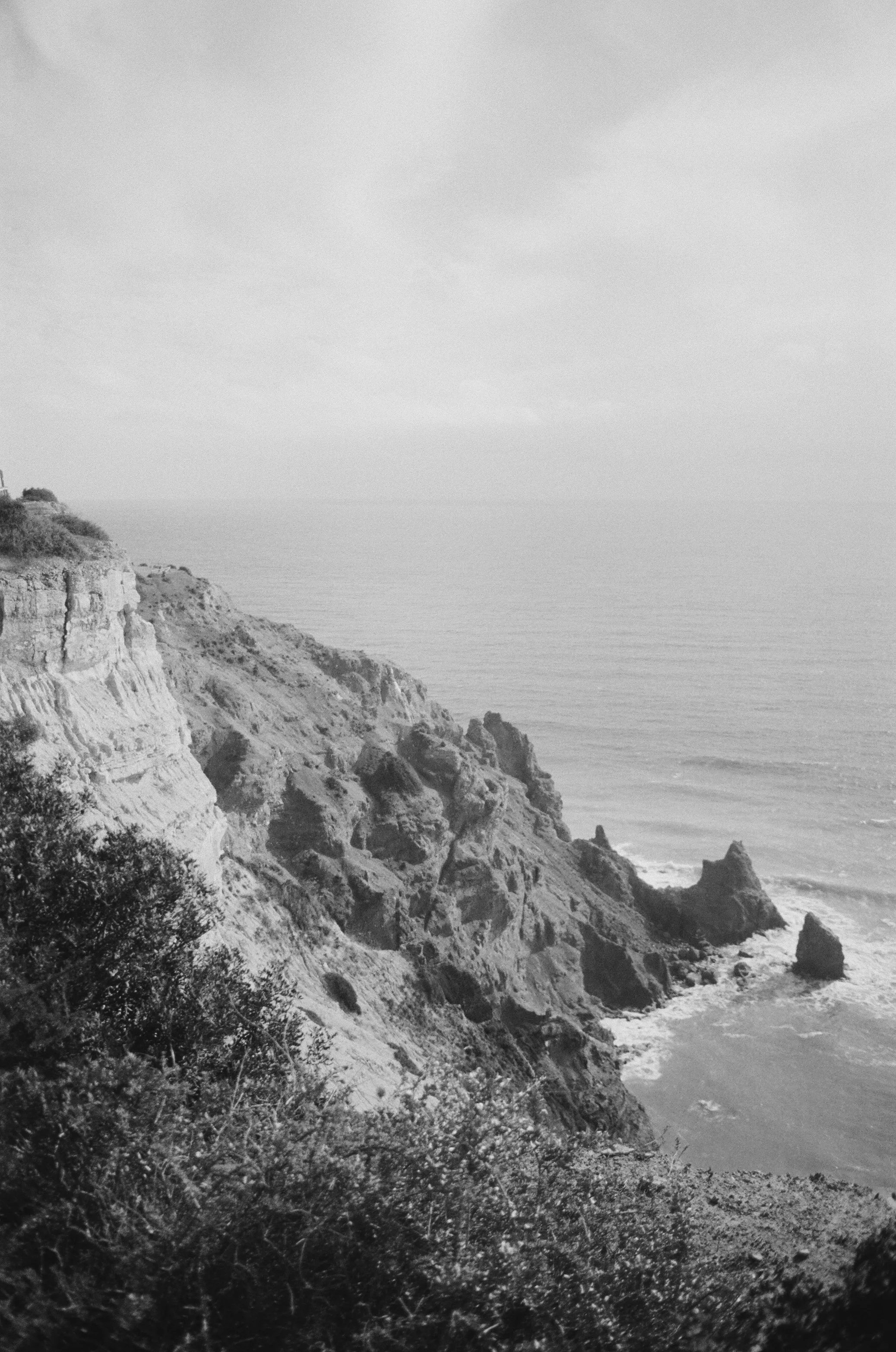 Analog black and white photograph of a rough coastline in the South of Portugal