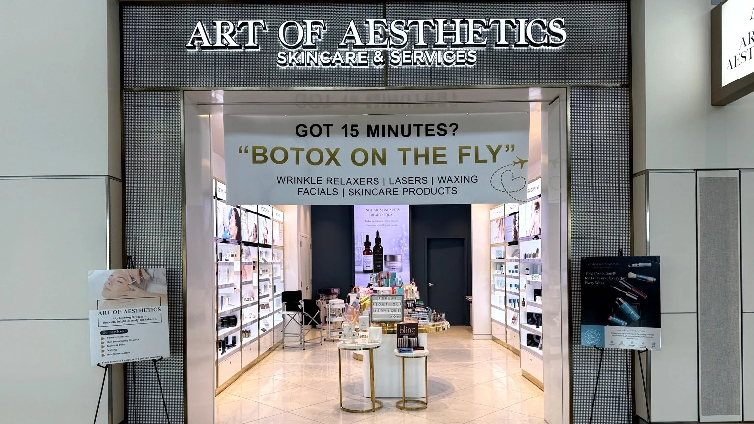 Entrance to Art of Aesthetics skincare and services store with promotional banner advertising Botox treatments, and display shelves with skincare products inside.