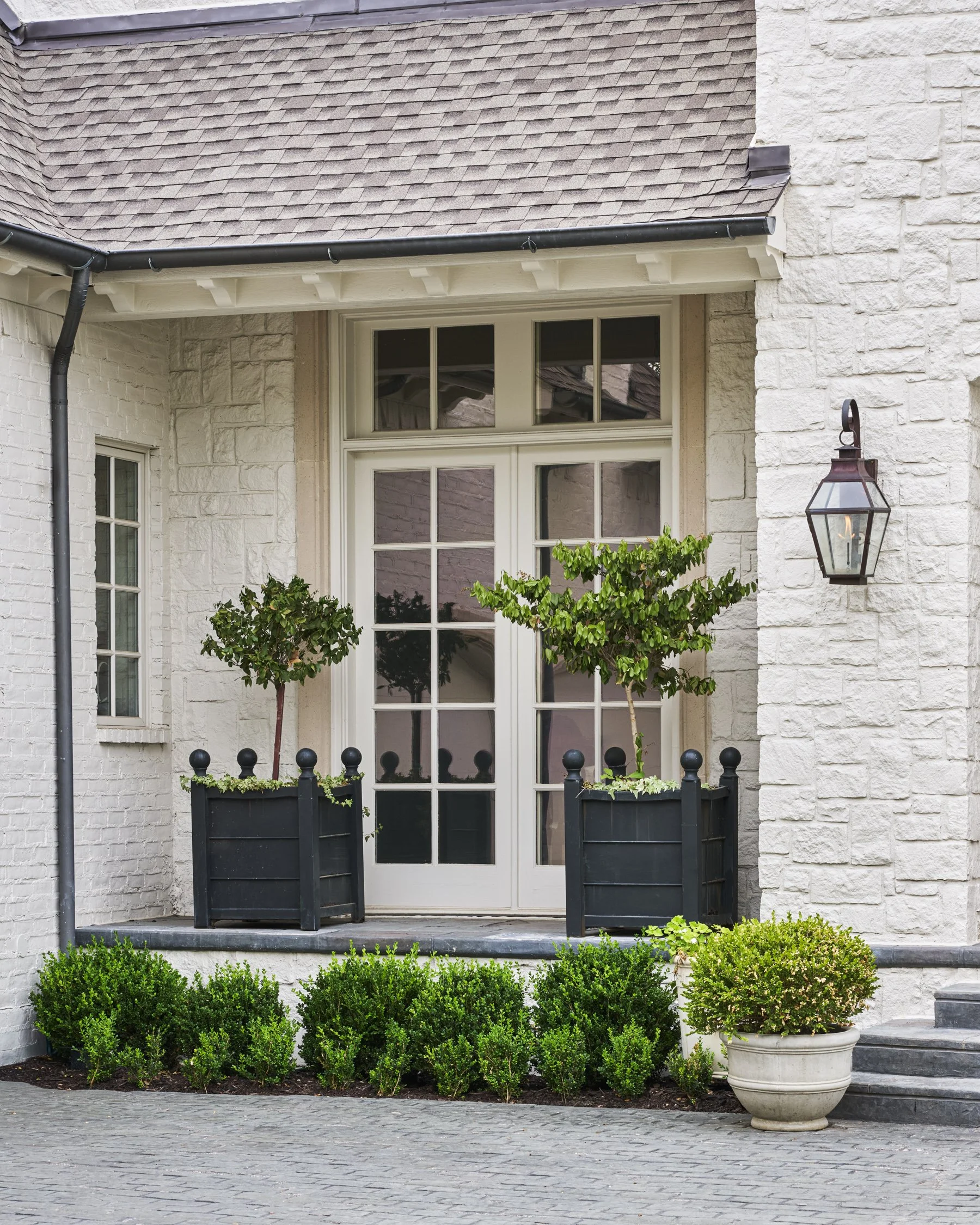 French-inspired front yard and motor courtyard landscape design with layered evergreen shrubs in the Park Cities  | Designed by Caroline Higgins Design in Dallas, TX