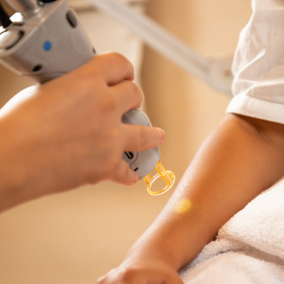 Close-up of a person's arm receiving a medical injection from a healthcare worker.