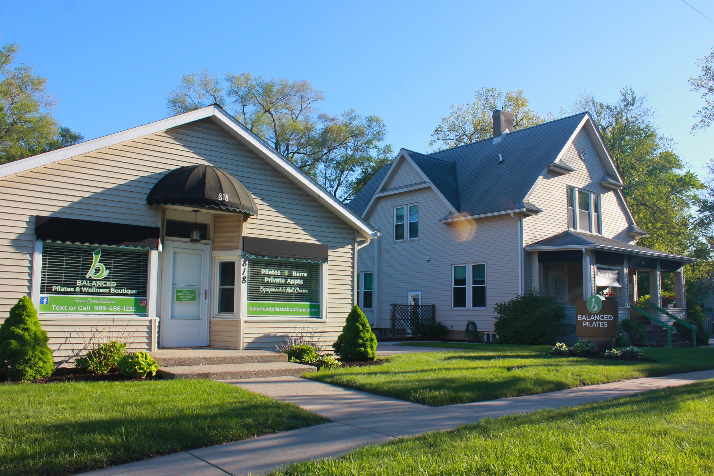 A small, beige building with a sign reading Balanced Pilates and Wellness Boutique in Midland, Michigan.
