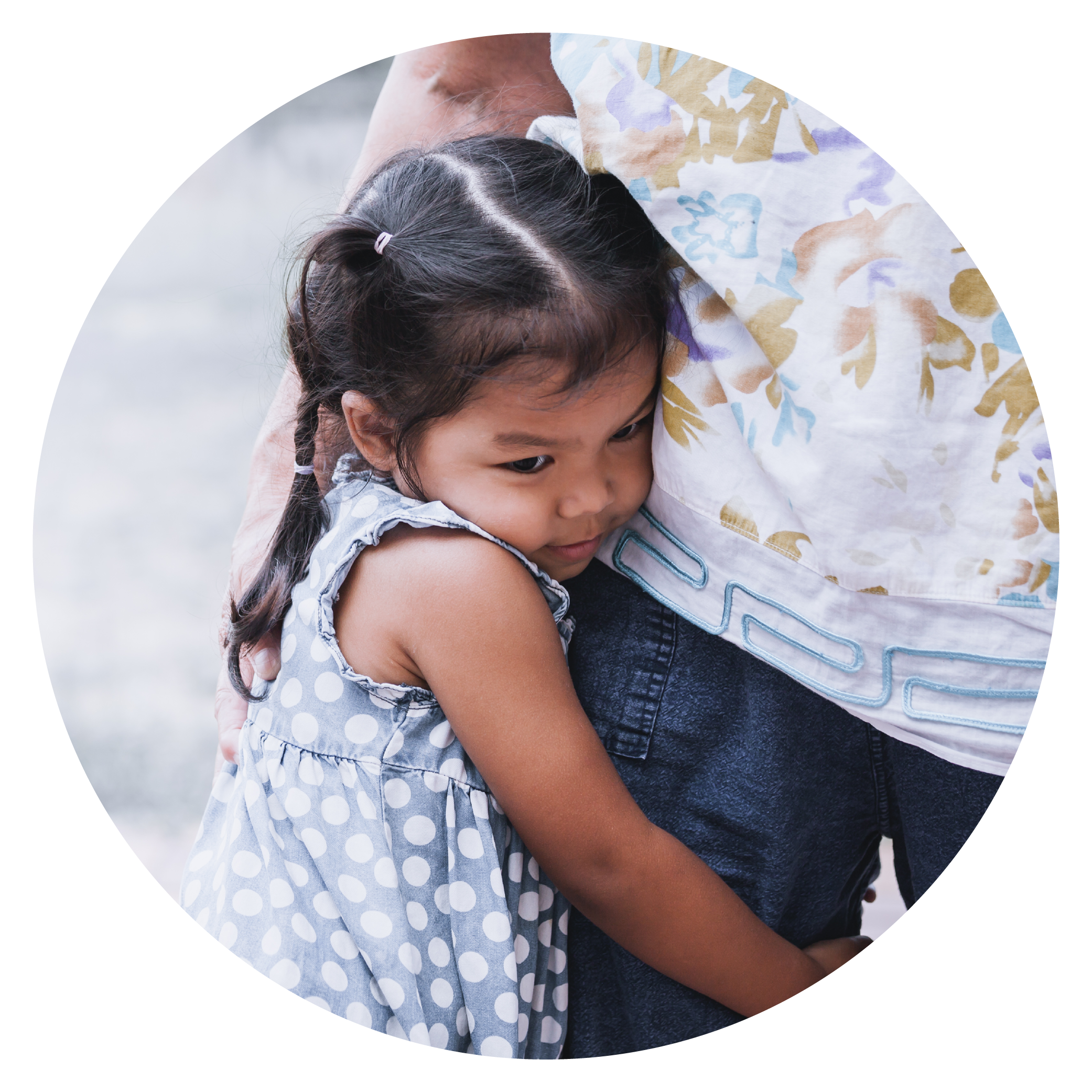 A young girl hugging an adult, possibly her parent, with a gentle and comforting expression.