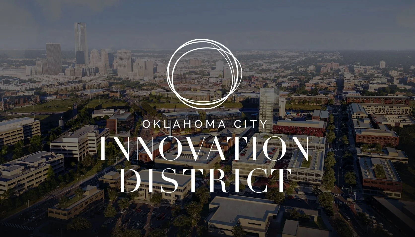 Aerial view of downtown Oklahoma City with overlay text 'Oklahoma City Innovation District' and a circular logo