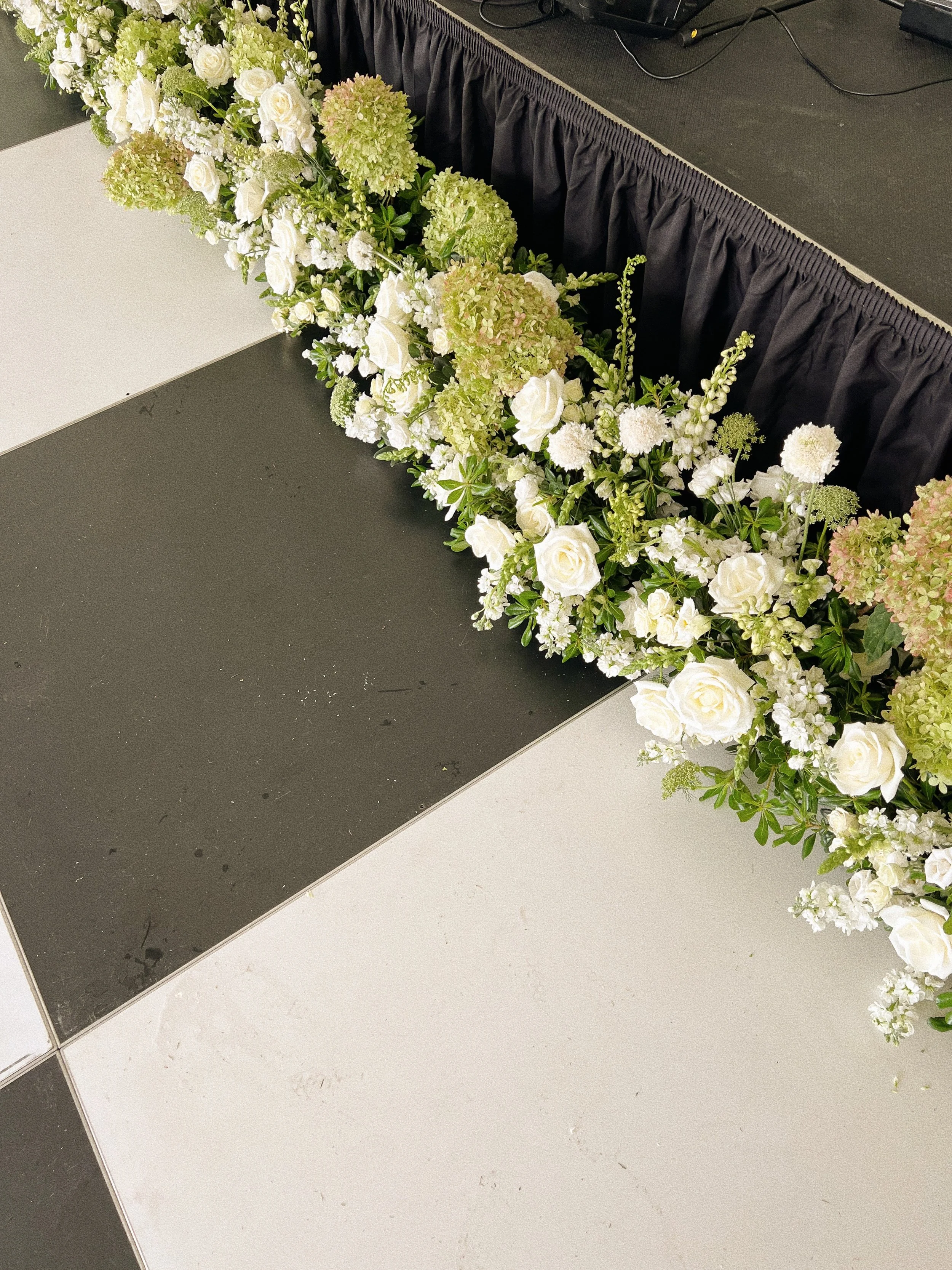 Dance floor florals in front of band stage