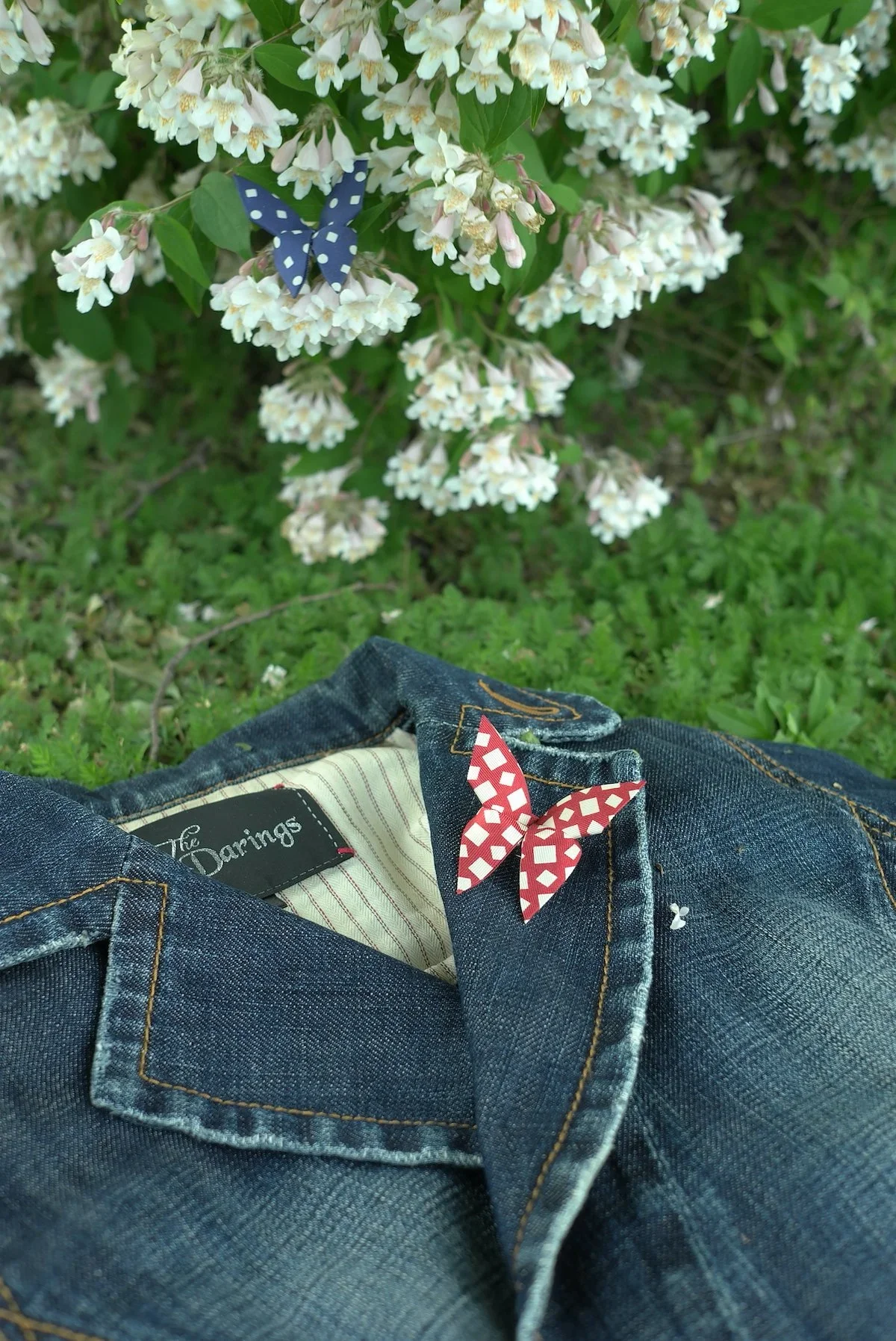 Un Buttertie, accessoire papillon en soie sur une veste en jean