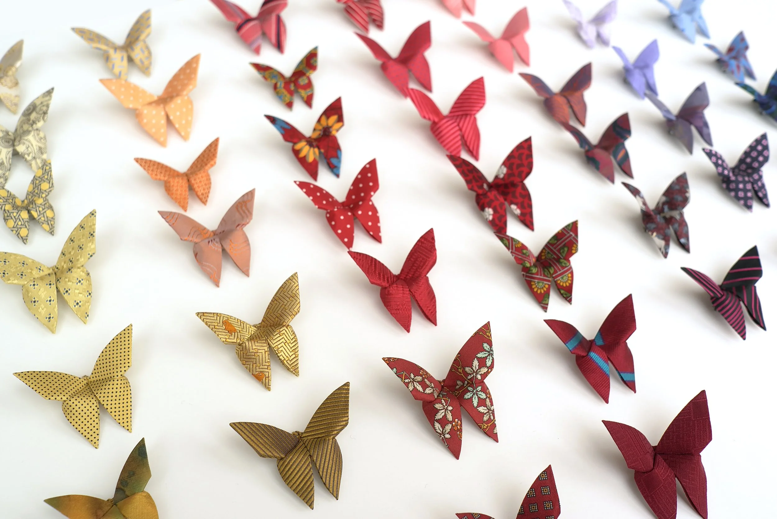 BUTTERTIES, Ce ne sont plus des cravates. Le pliage origami est transposé sur soie, donnant naissance à un nouveau savoir-faire artisanal. La diversité infinie de ces cravates récupérés, revalorisés et métamorphosées en papillons