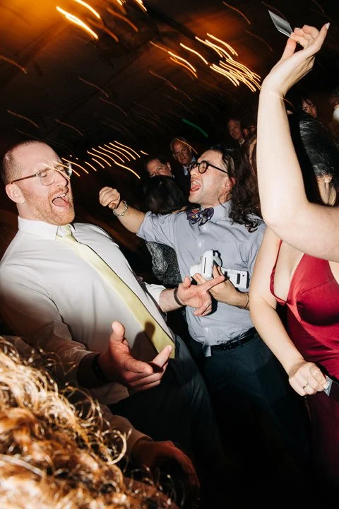 People dancing and celebrating at a party, with joyful expressions and lively movement.