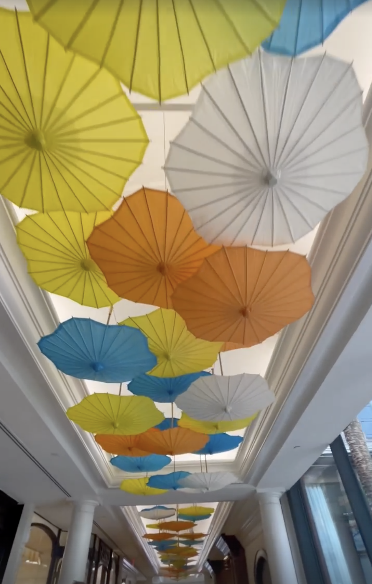 Colorful umbrellas hanging from the ceiling in a decorative indoor space.