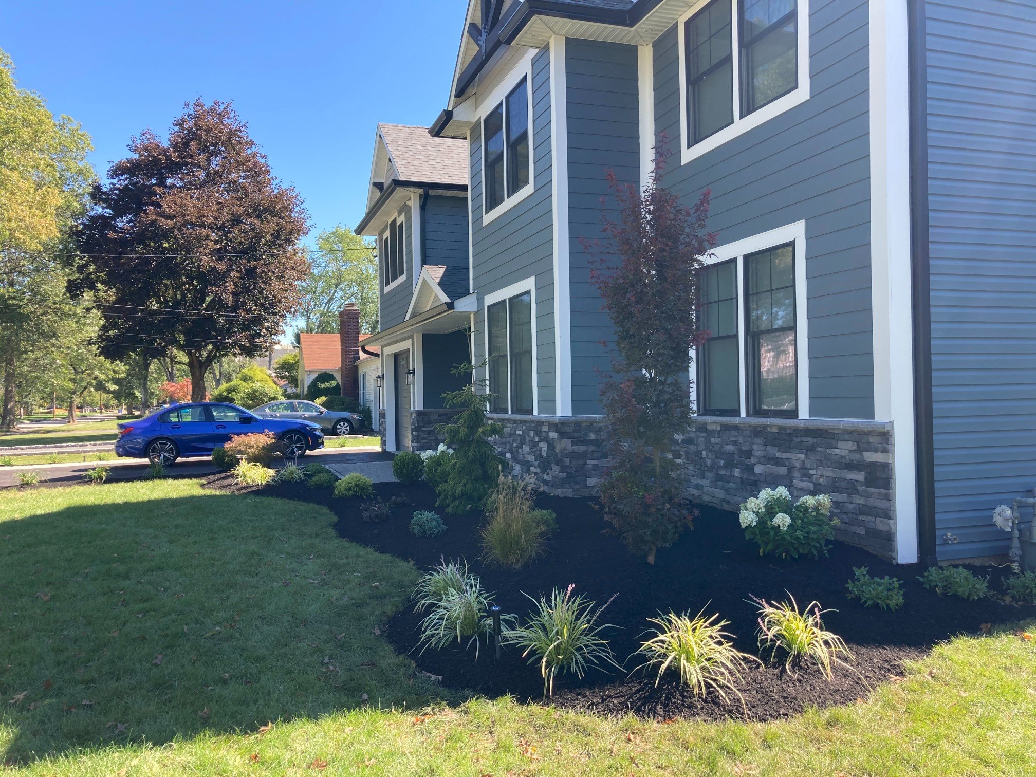 Professionally installed planting beds adding depth to a front yard. - Green Nature Landscape Design