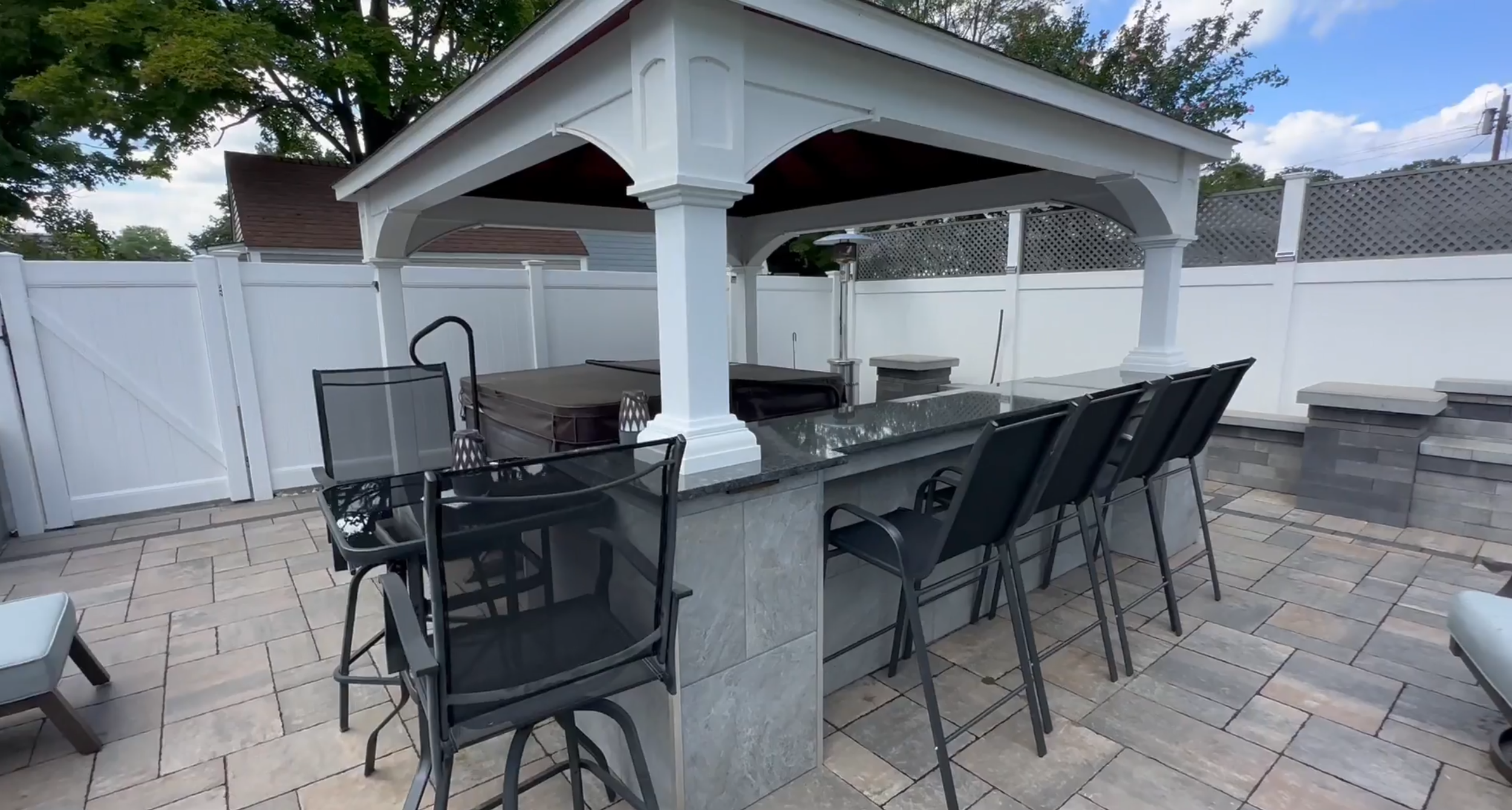 A custom outdoor cooking space with paver patio and outdoor lighting. - Green Nature Landscape Design