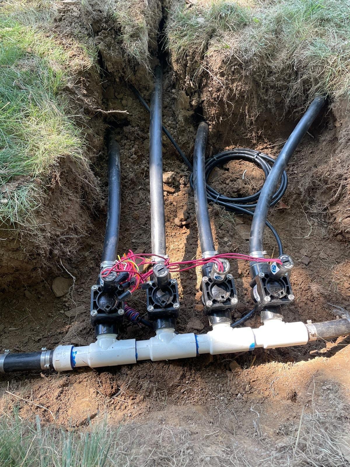 A residential irrigation contractor inspecting a sprinkler system. - Green Nature Landscape Design