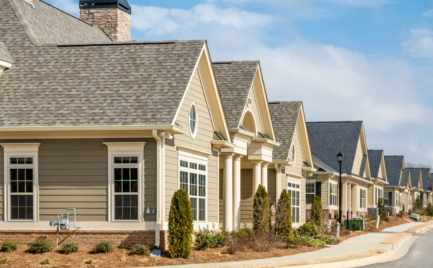 HOA community building with trimmed evergreen shrubs and maintained landscaping along the front entrance.