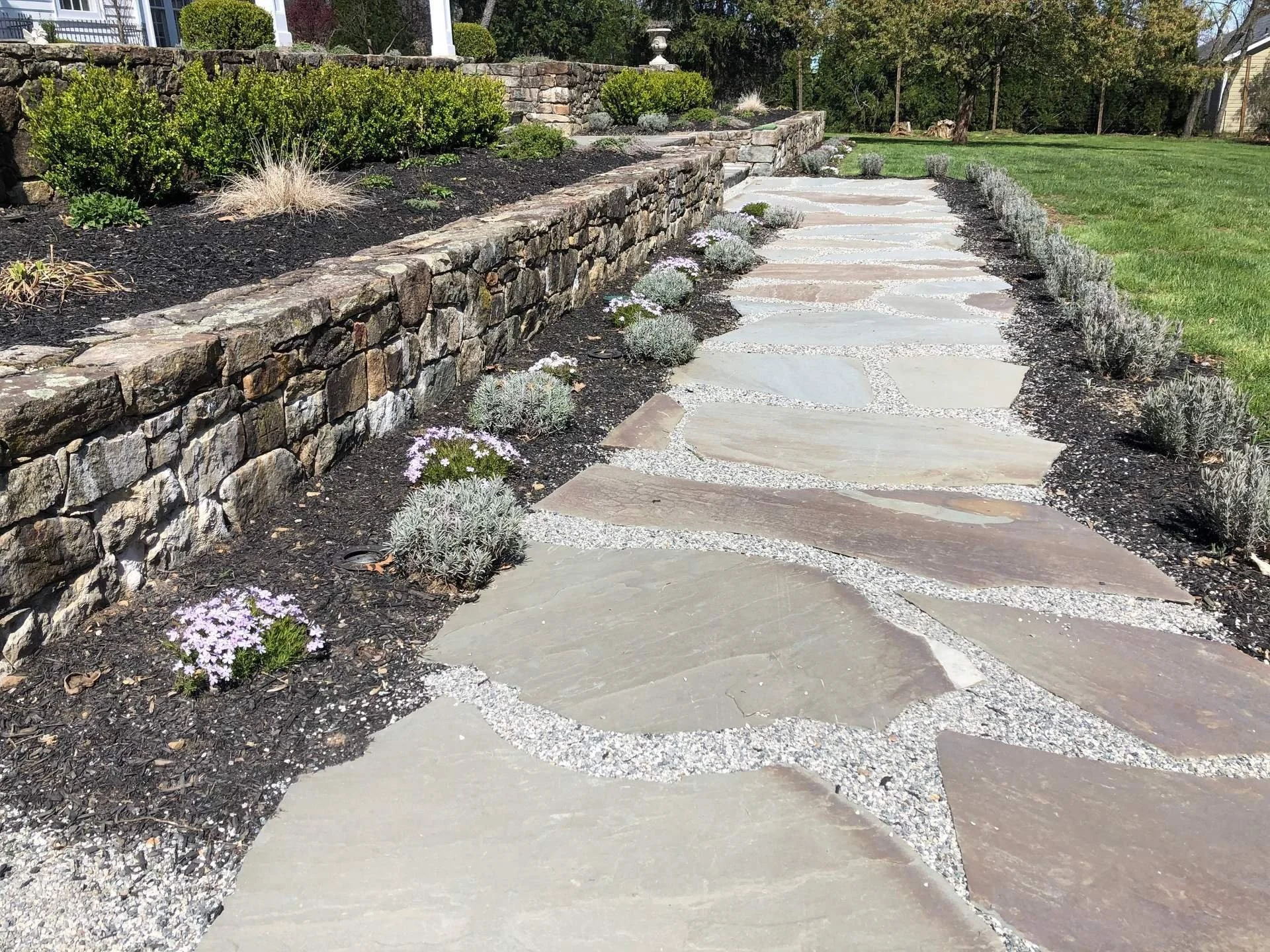 A seating wall defining the edge of a walkway.
