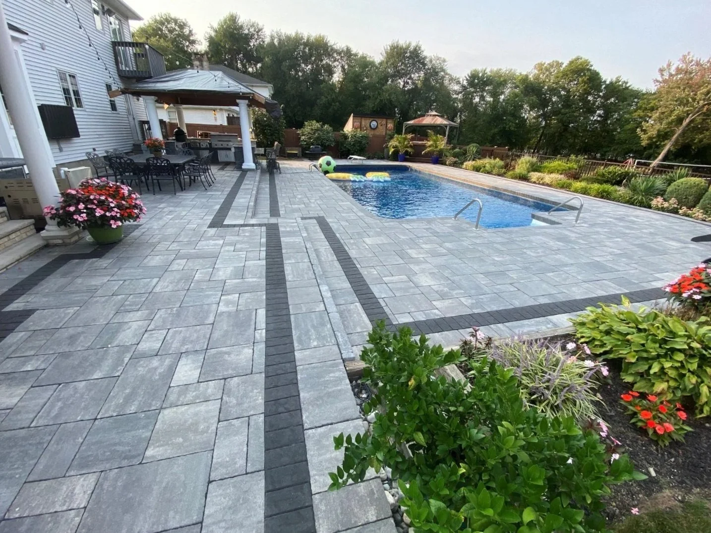 Outdoor living landscape design with custom pool area and elegant hardscape in Chatham, NJ