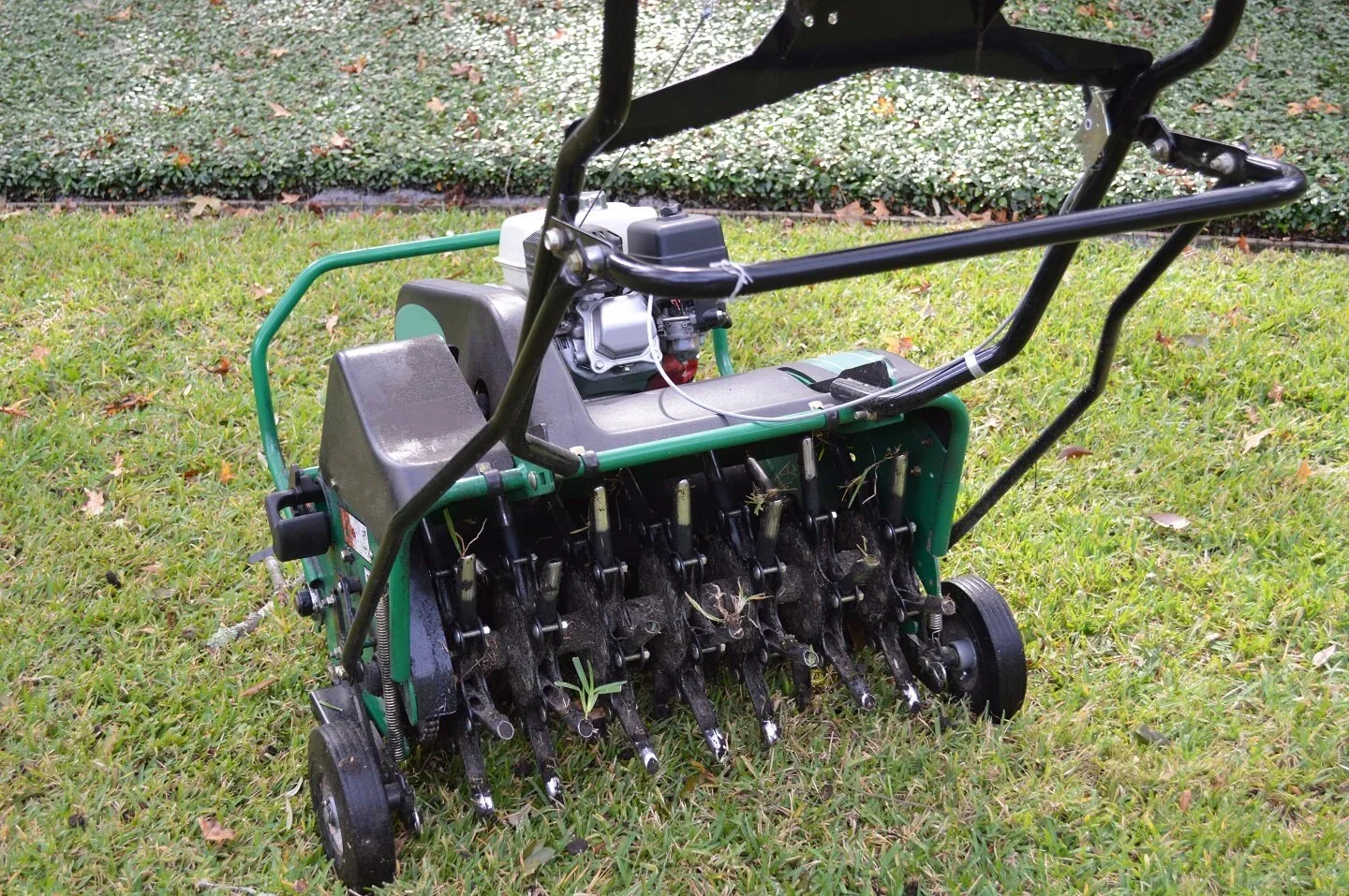 Gas-powered lawn core aerator machine on a grass lawn