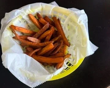 Basket of sweet potato fries on white paper liner