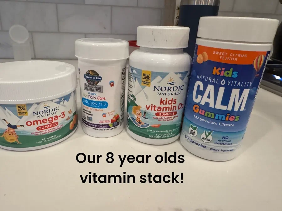 A collection of children’s vitamins and supplements including Nordic Naturals Omega-3 gummies, a probiotic supplement, Nordic Naturals Kids Vitamin D3 gummies, and Kids Calm Gummy magnesium citrate, arranged on a countertop with a caption about them 