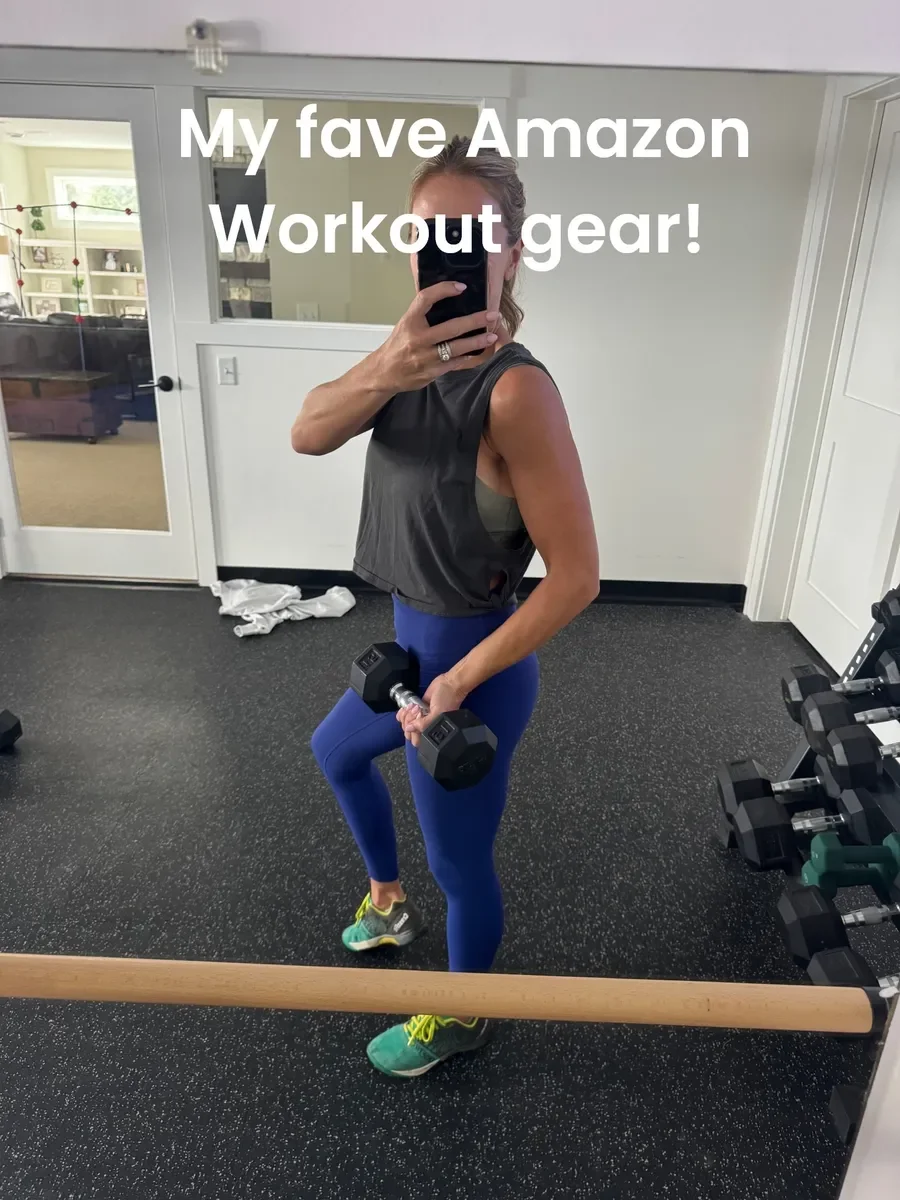 Woman in workout clothes taking a mirror selfie at the gym, holding a dumbbell in one hand, with the text 'My fave Amazon Workout gear!' overlaid.