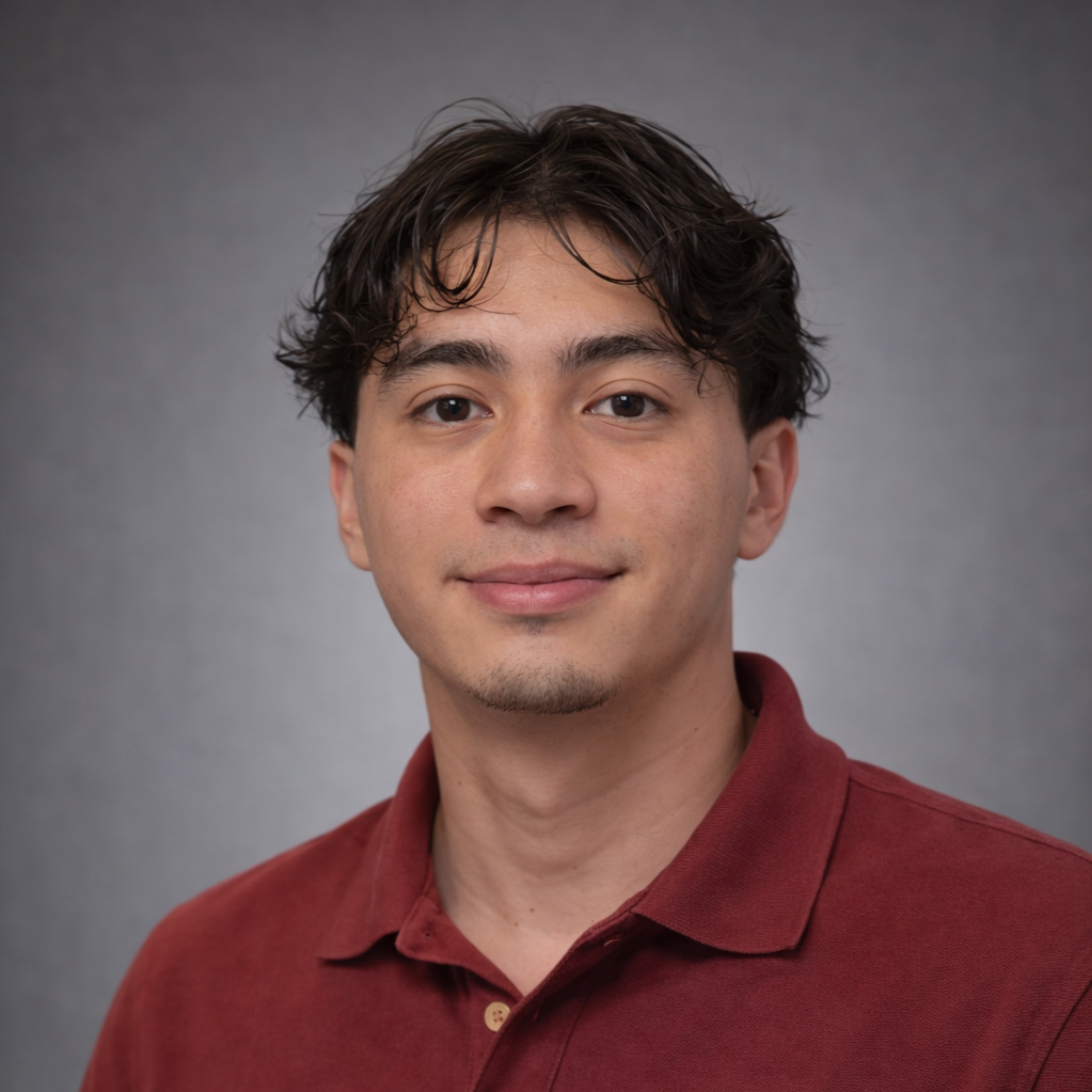 A young man with dark, wavy hair and light skin, wearing a maroon polo shirt, smiling lightly against a gray background.