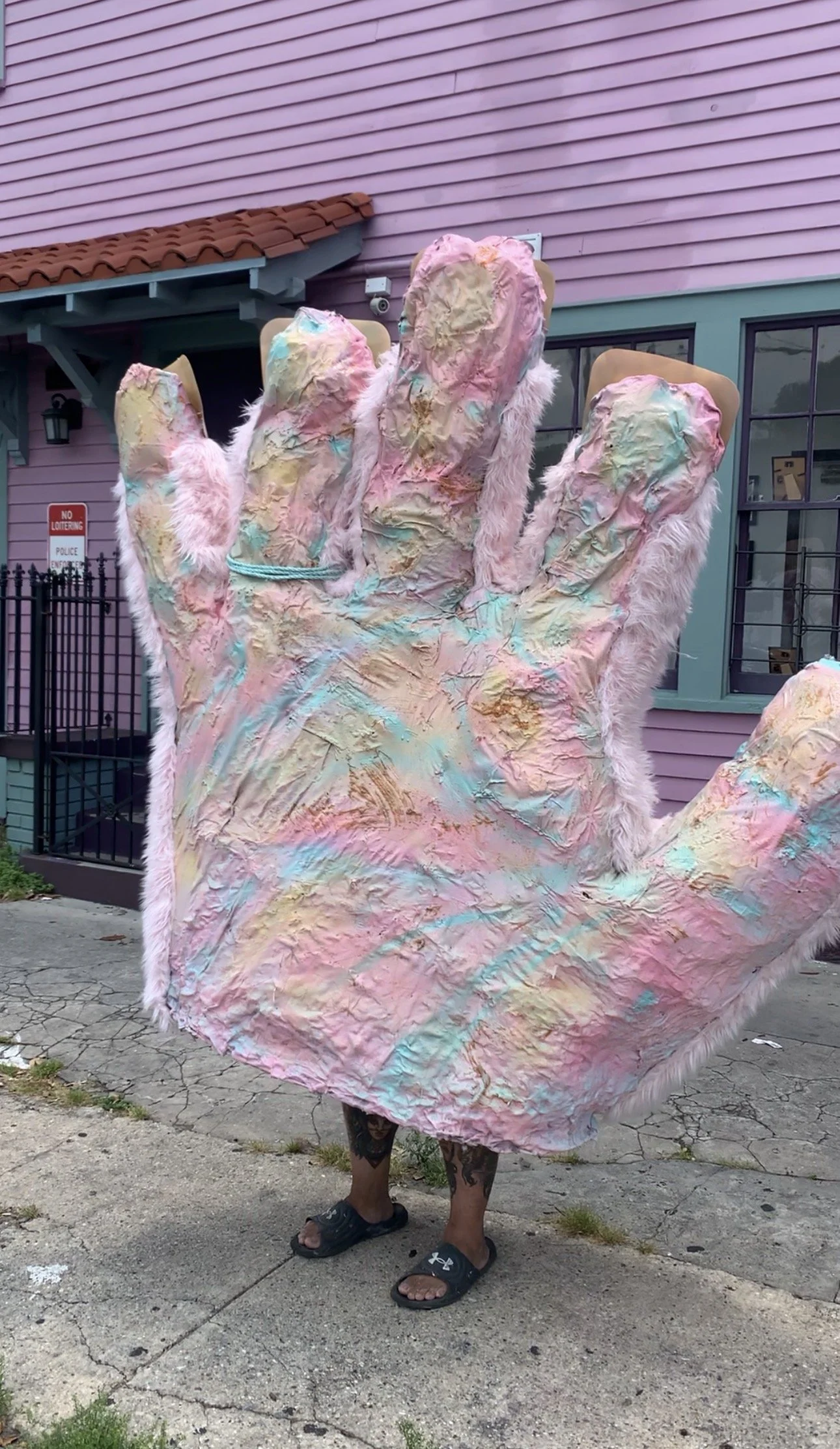 A wearable giant furry puppet hand with one operator. Each finger is posable, the hand is made of mesh.
