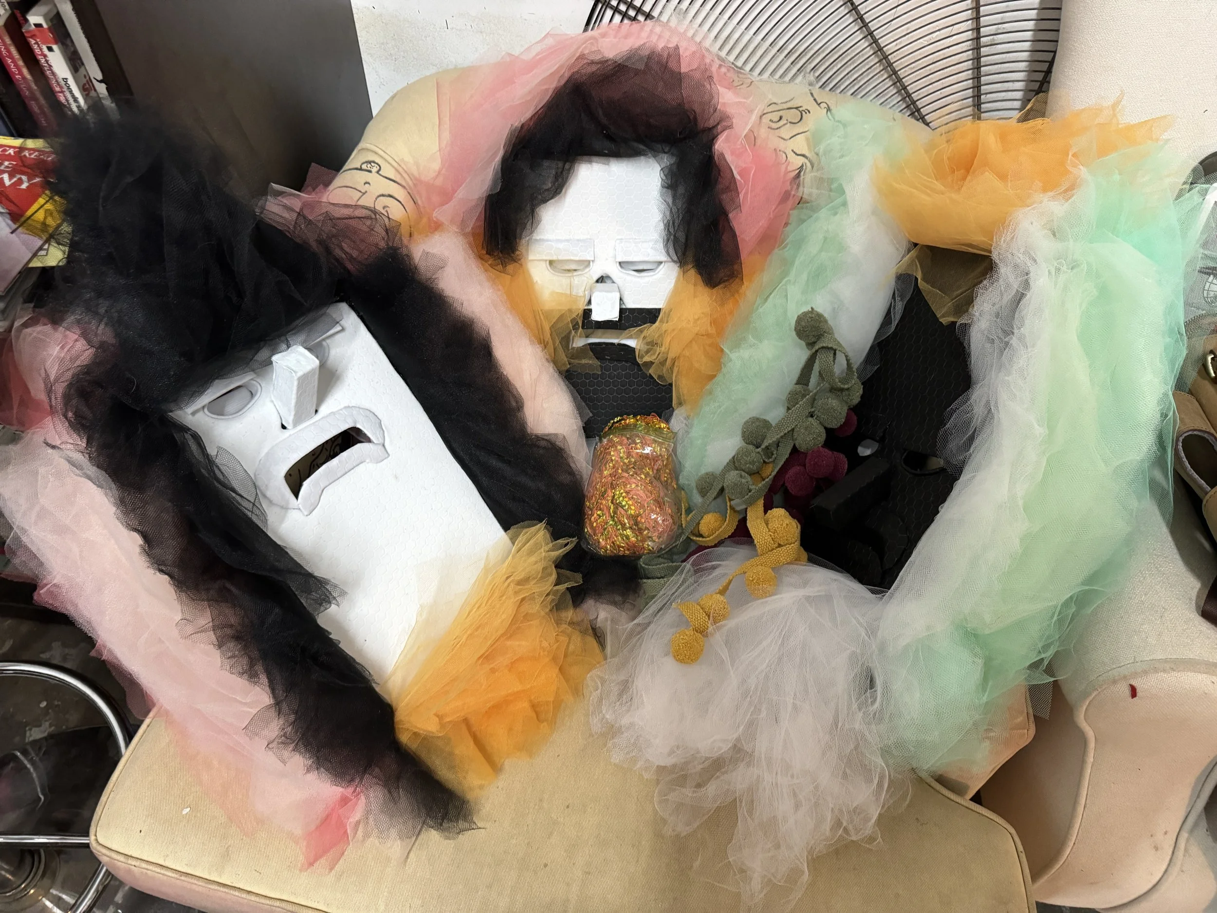 Studio materials for The Chloe Hotel installation showing mask forms, tulle, and mixed-media components in progress.