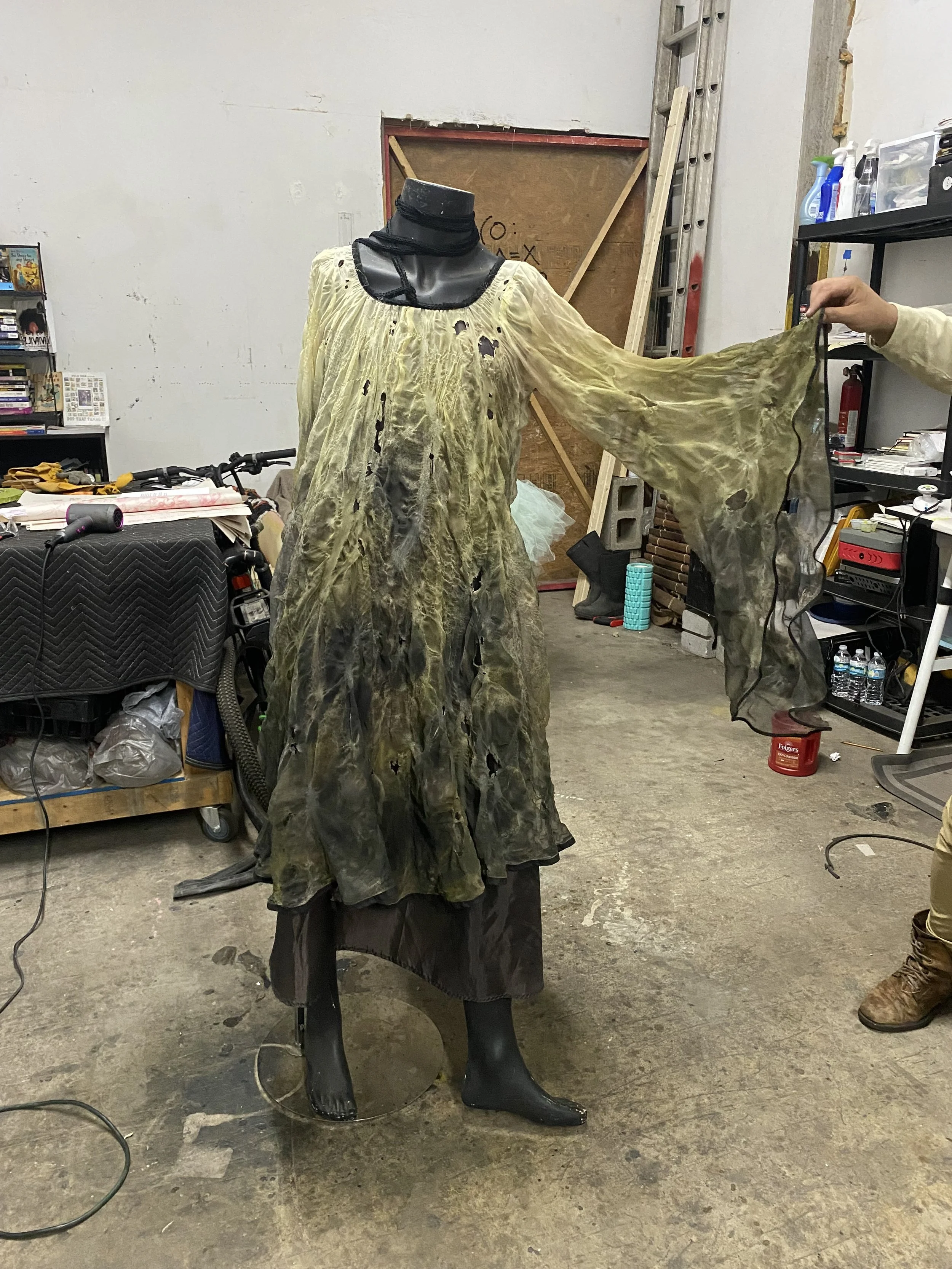Distressed green dress created by Basqo Bim for Duckboy – Excalibur displayed on a mannequin in the studio.