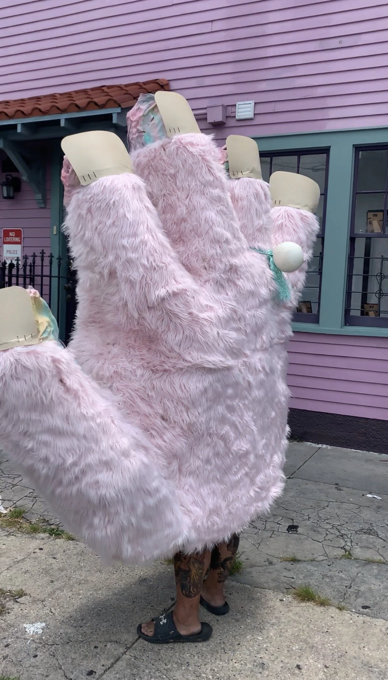 A wearable giant furry puppet hand with one operator. Each finger is posable, the hand is made of mesh.